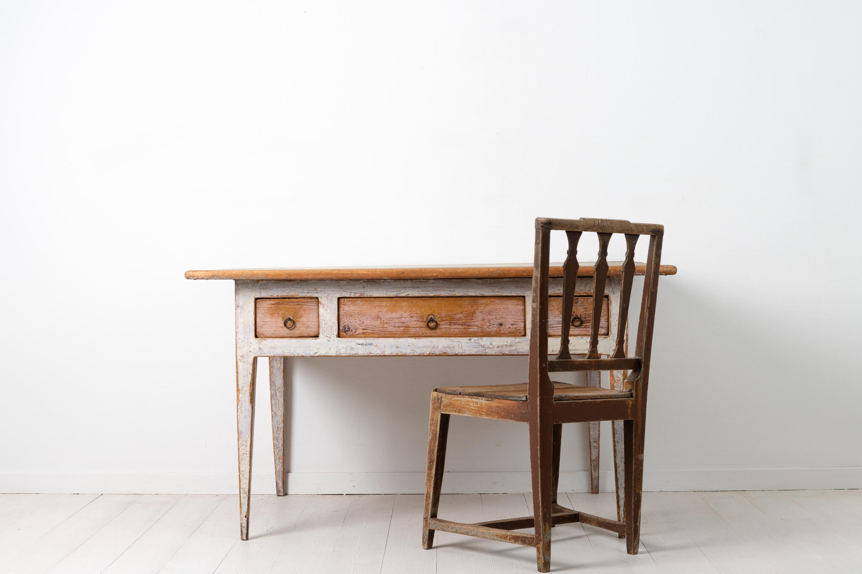 Gustavian Provincial country table from the first few years of the 19th century, between 1800 and 1810. The table is from northern Sweden and a provincial work in painted pine with 3 drawers and straight tapered legs. It has the original light paint