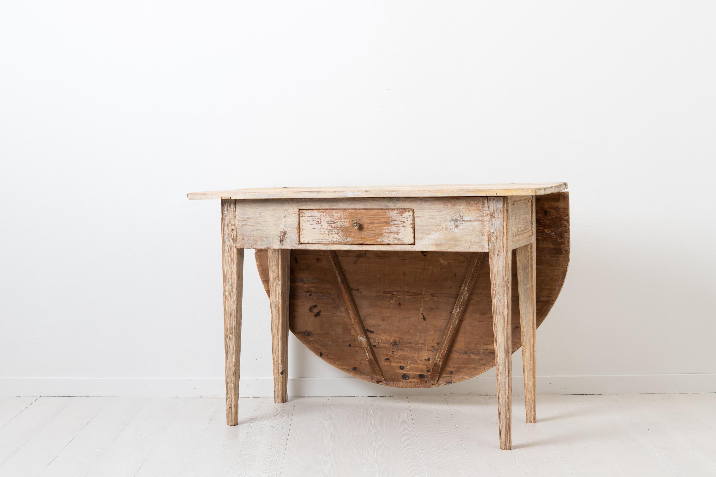 Weißer Gustavianischer Tisch, hergestellt in Nordschweden zwischen 1790 und 1810. Der Tisch ist ein frühes Beispiel für kompaktes Wohnen, bei dem ein Gegenstand mehrere Verwendungsmöglichkeiten hat. Dieser Tisch hat eine klappbare Tischplatte und
