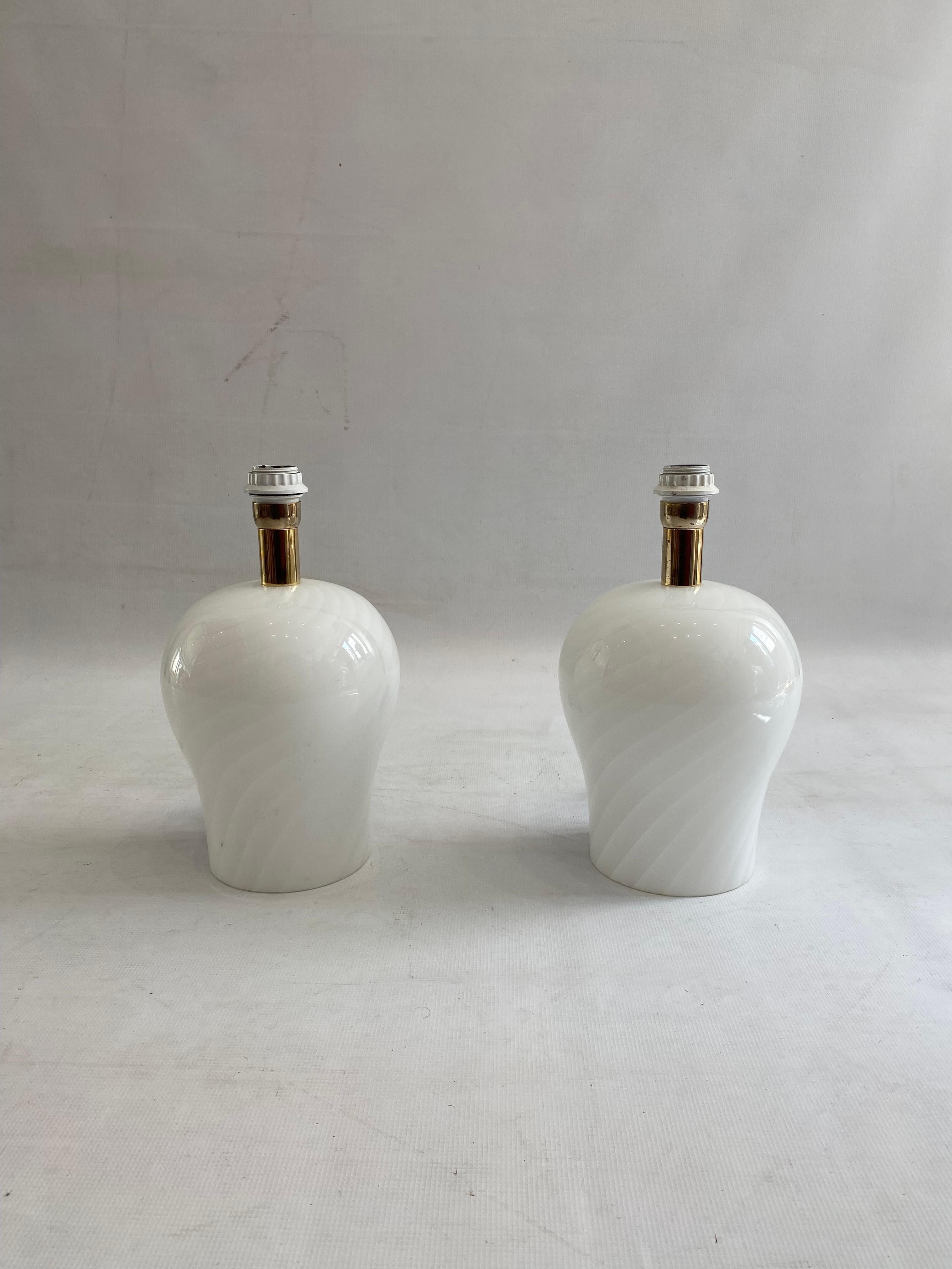 A minimal but a beautiful pair of Murano lamps in swirl handblown glass technique with gold plated lamp holder.

The lamps have a bulbous hourglass shape with an easy design that would make them fit in almost most interiors. they would look great in