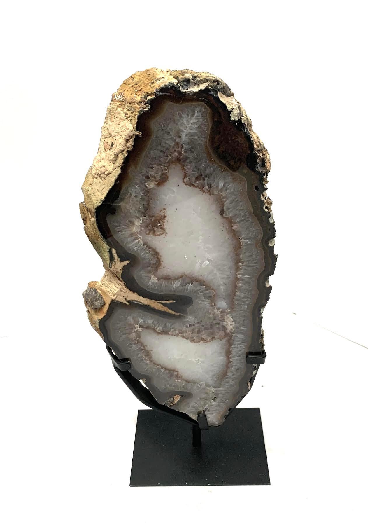 Prehistoric Brazilian agate geode on stand.
White, taupe with a thin rust line.
Metal stand measures 6