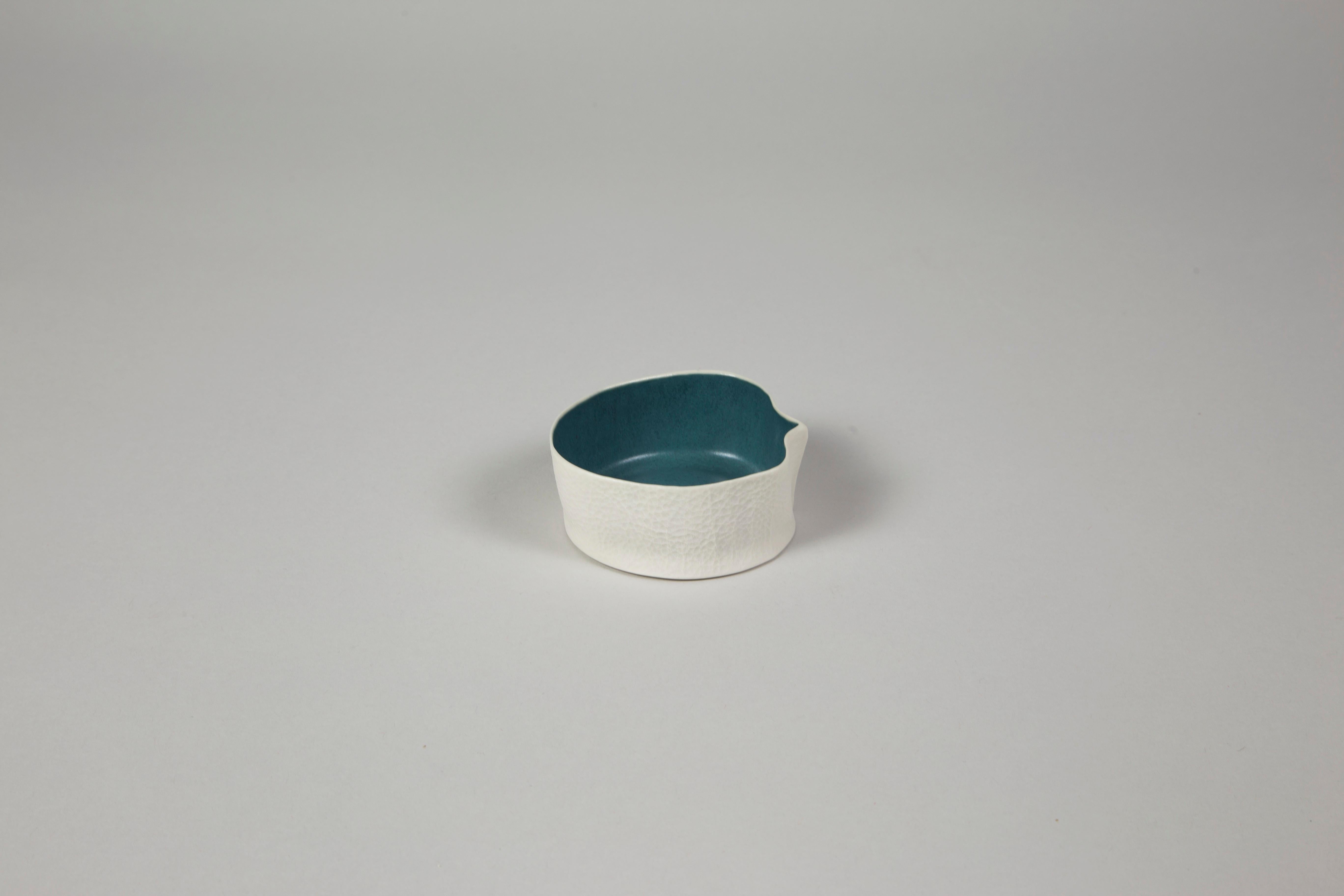 An organic shaped porcelain bowl with a tactile exterior surface and a smooth glazed interior. Small & precious, yet surprisingly practical, the Kawa Dishes are equally well-suited as a jewelry dish, salt cellar, sauces & dips bowl. As a result of