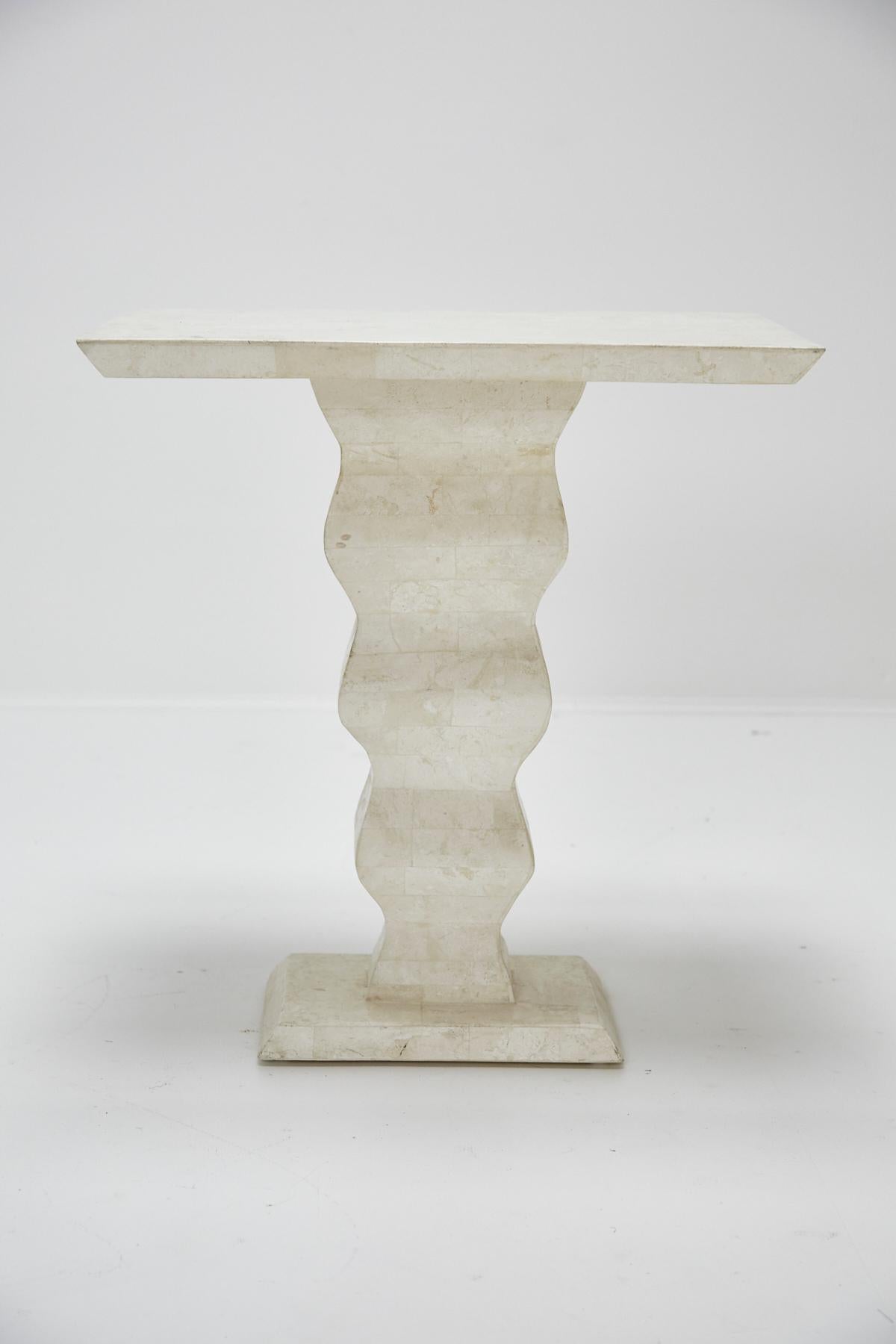 Side, end or occasional table with rectangular top and wavy central pedestal base, entirely covered in white tessellated stone over a fiberglass and wooden body.