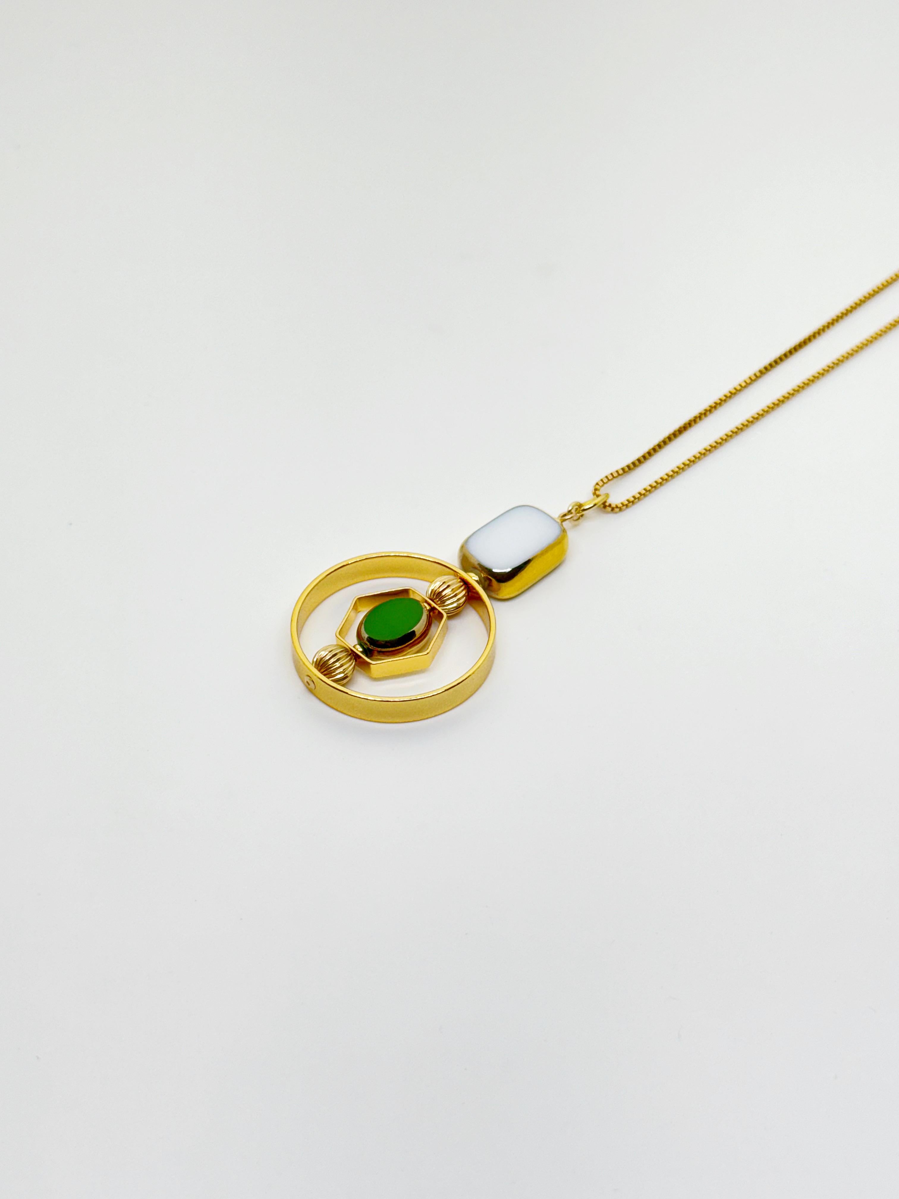 The pendant consists of white tile shape and small green oval new old stock vintage German glass beads that are framed with 24K gold. The beads were hand-pressed during the 1920s-1960s. No two beads are exactly alike. These beads are no longer in