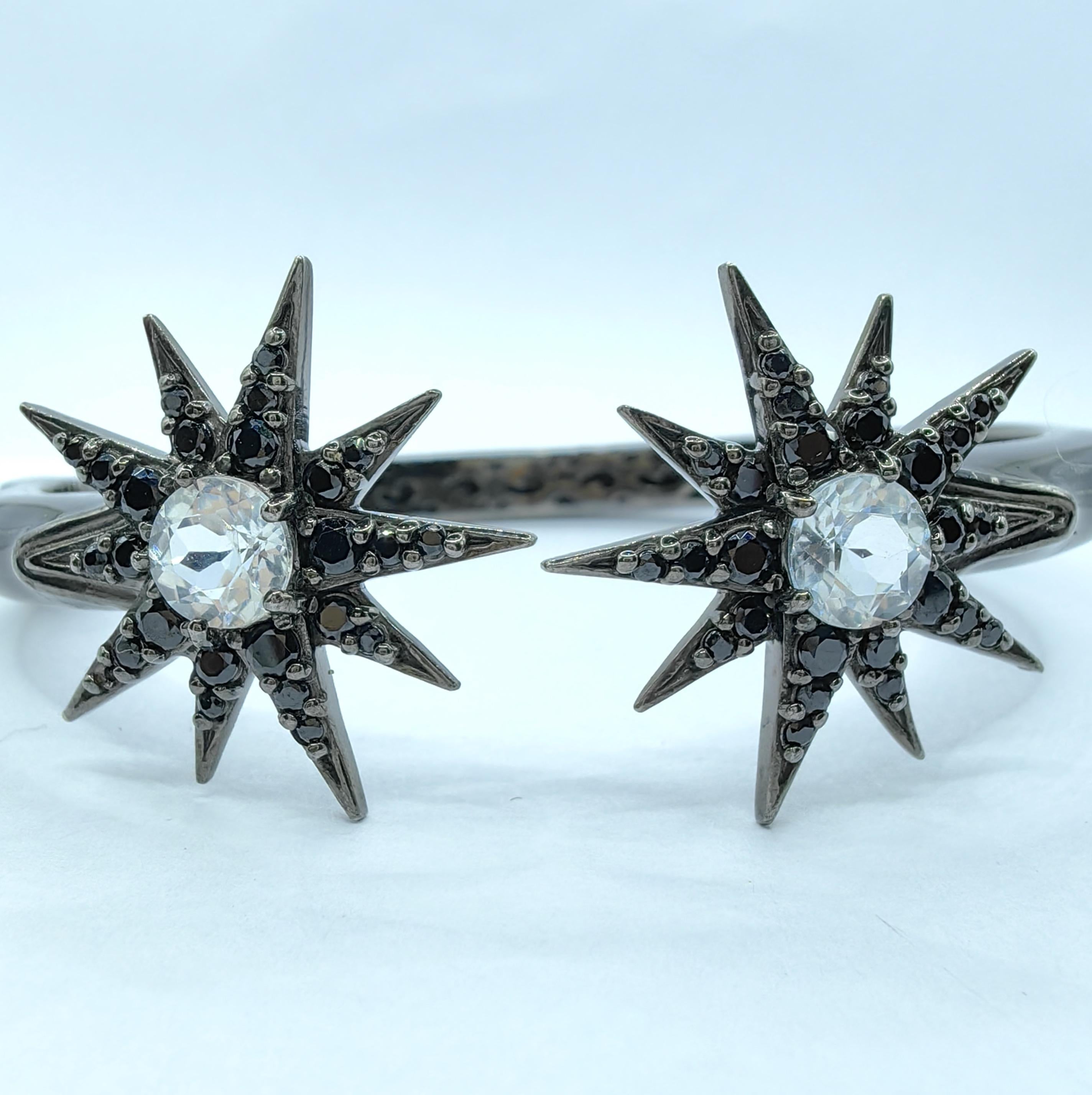 Illuminate your style with the sleek elegance of this Diamond and Black Sapphire Starburst Motif Cuff Bracelet in Sterling Silver. Featuring 1.8ct of round cut white topaz and 1.62ct of black sapphires, this bracelet combines a striking starburst
