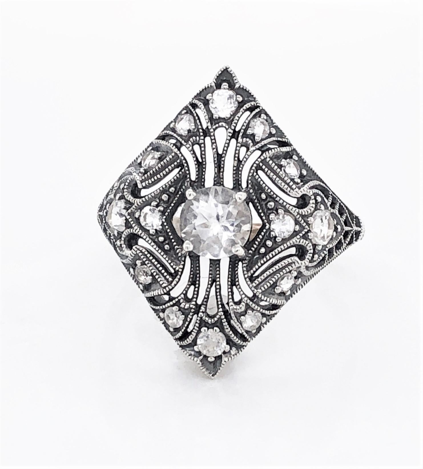 Love the shape of this Art Deco Style inspired design in sterling silver filigree with genuine gemstones. With exquisite detail reminiscent of the period, this ring has a featured  .20 carat round faceted white topaz with additional accents