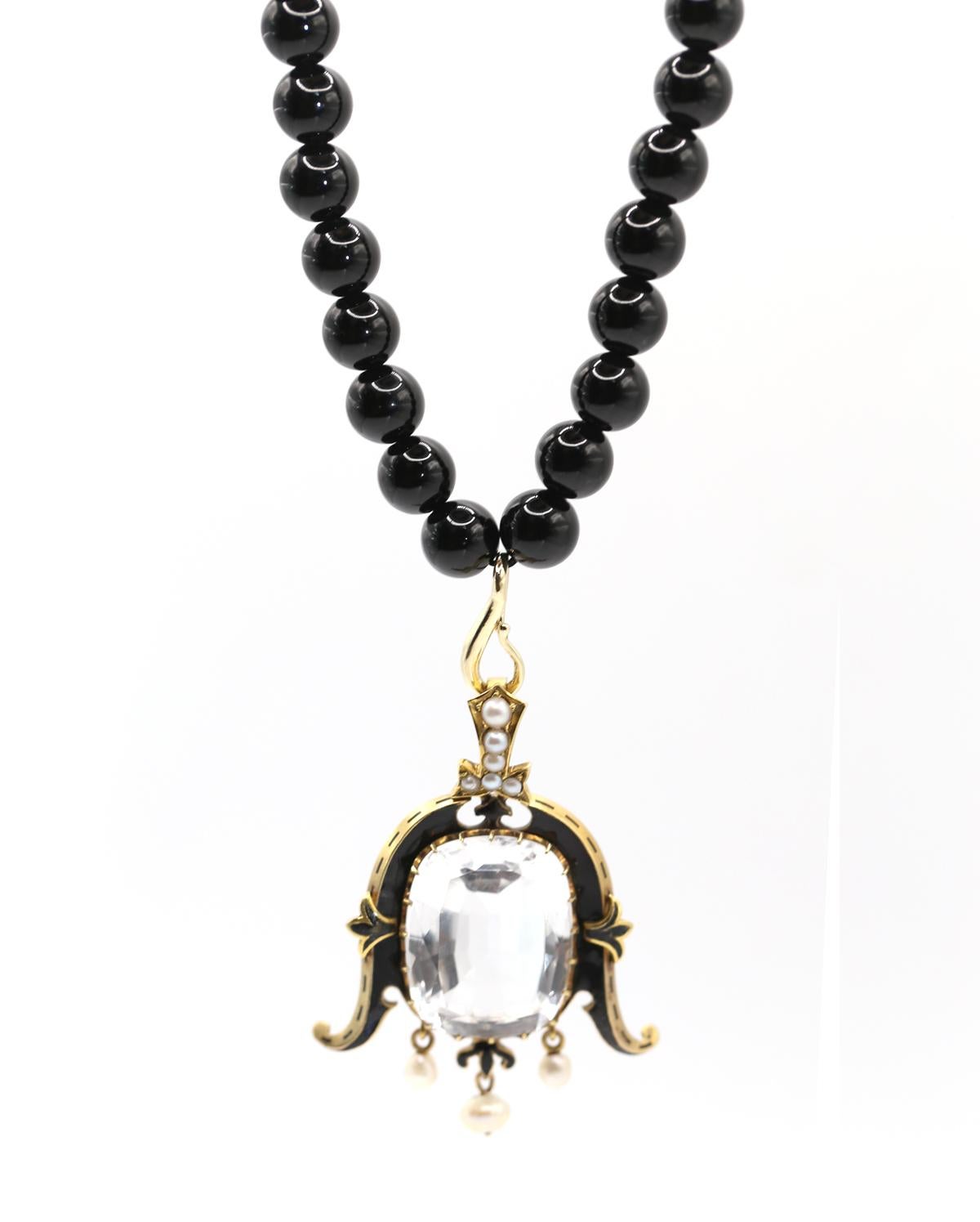 Pendentif ancien en or jaune composé de topaze blanche, de perles et d'émail, c.1890

Vue d'ensemble
Remarquable pendentif de la fin du XIXe siècle en or jaune, serti d'une grande topaze blanche, de perles et d'accents d'émail noir. Créé vers 1890,