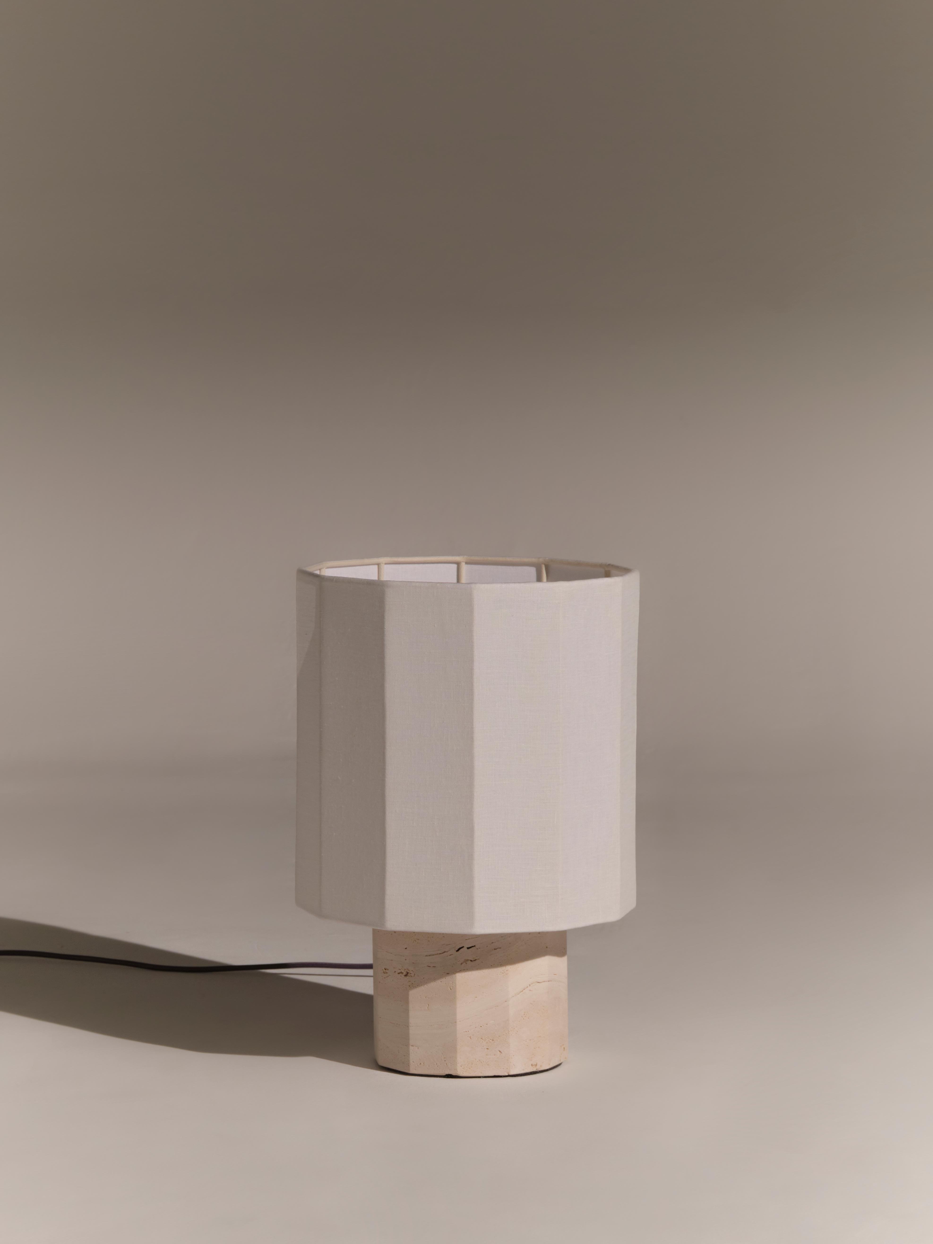 Lampada da tavolo in travertino bianco Roma II Dodecagon di NASSI
Dimensioni: L 30 x P 30 x H 44 cm. 
Materiali: Fodera in cotone pregiato, tessuto in puro lino bianco. 
Base: Travertino bianco, ottone nichelato. 
Peso: 9 kg

Disponibile anche in 4