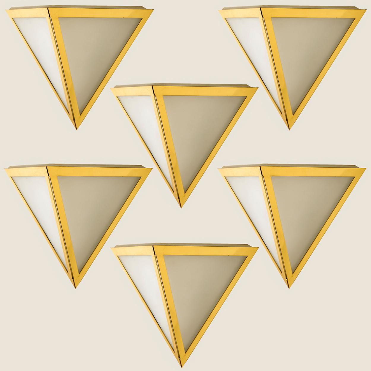 Triangle shaped wall lights in white opaline glass with brass details. Manufactured by Glashütte Limburg in Germany during the 1970s. (early 1970s). Nice craftsmanship. Minimal, geometric and simply shaped design.

Please note the price is for one