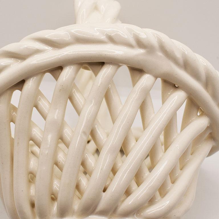A beautiful white ceramic basket. This piece features woven ceramic braids surrounding a small basket with a handle. 

Dimensions:
6