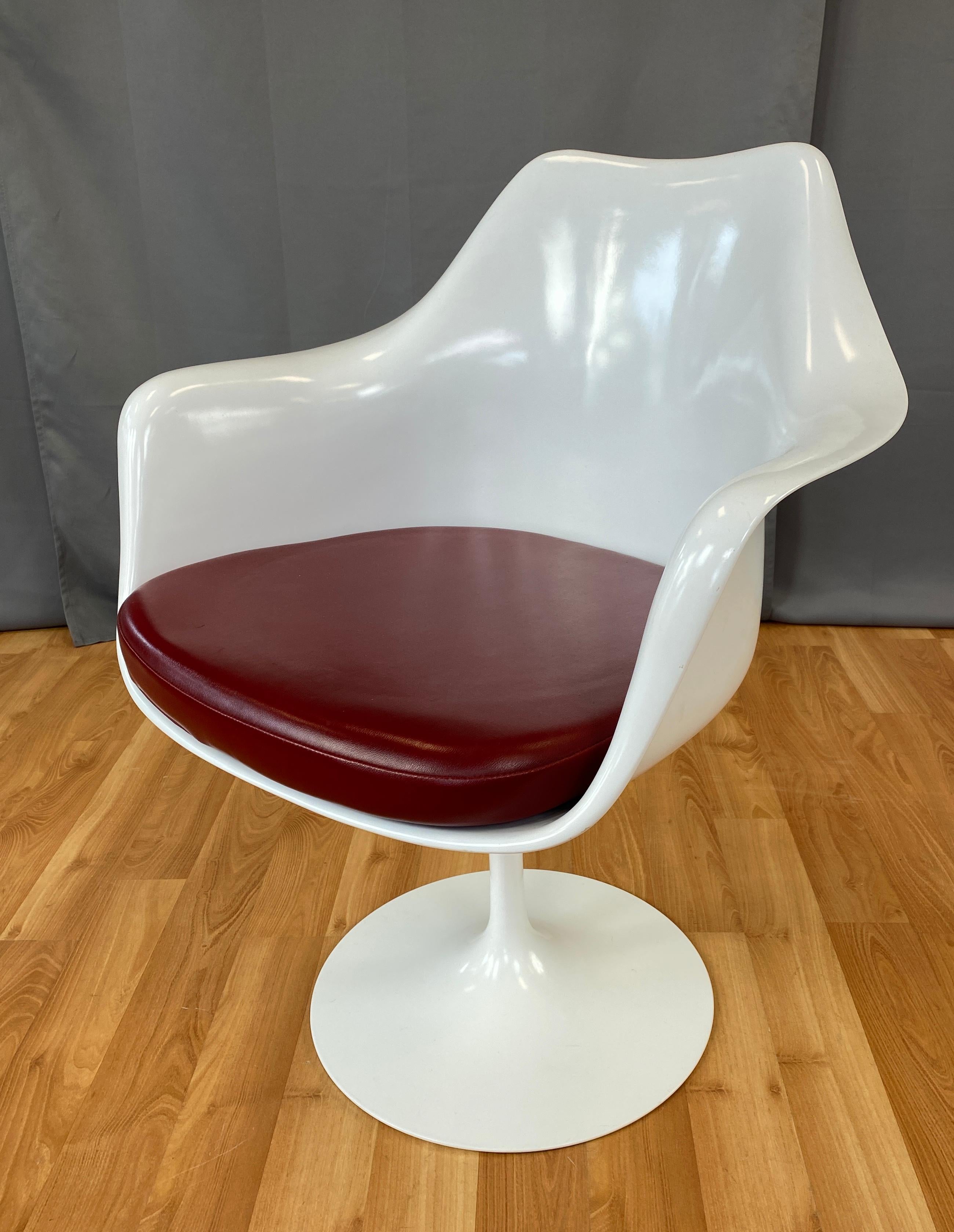 Offered here is a white Tulip armchair designed by Eero Saarinen and made by Knoll.
All white chair, with Ox Blood leather upholstery, on Knoll's web site we think it's Yolo Leather Garnet.
 
