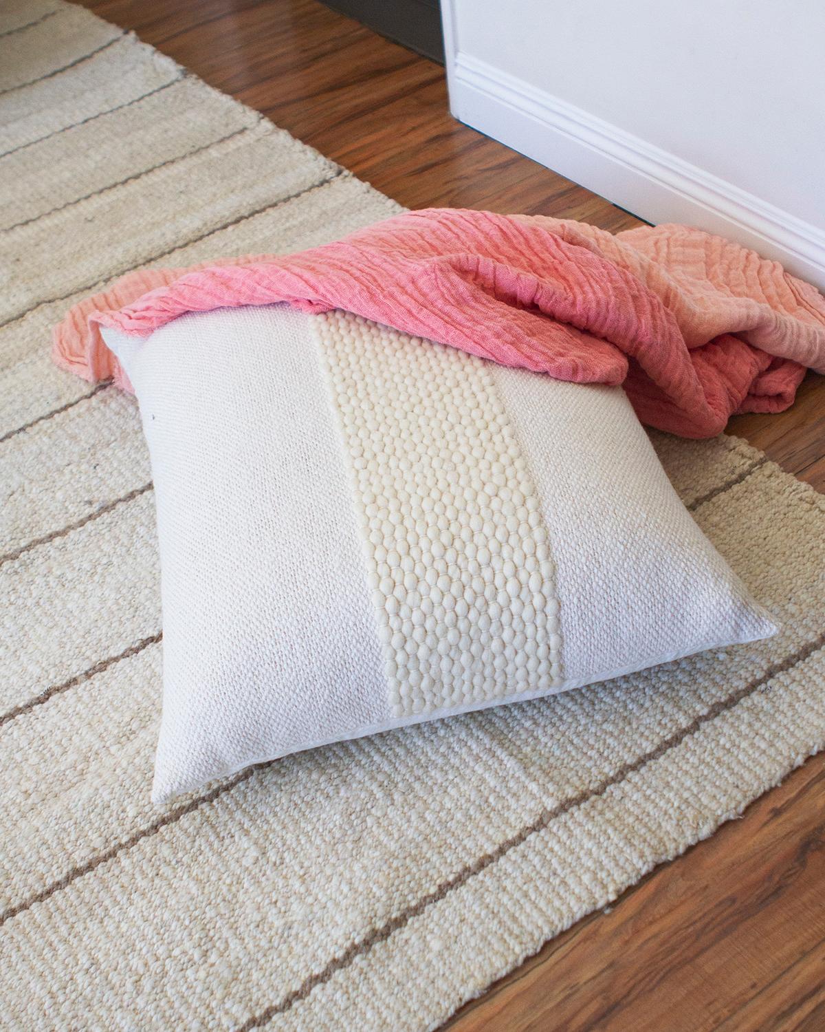 Ein strukturiertes weißes Kissen für Ihre Wohnzimmercouch. Das stilvolle Valle Kissen aus Baumwolle und Wolle ist perfekt, um jeder Einrichtung einen modernen, rustikalen Touch zu verleihen. Handgefertigt aus einer Kombination von weißer Baumwolle