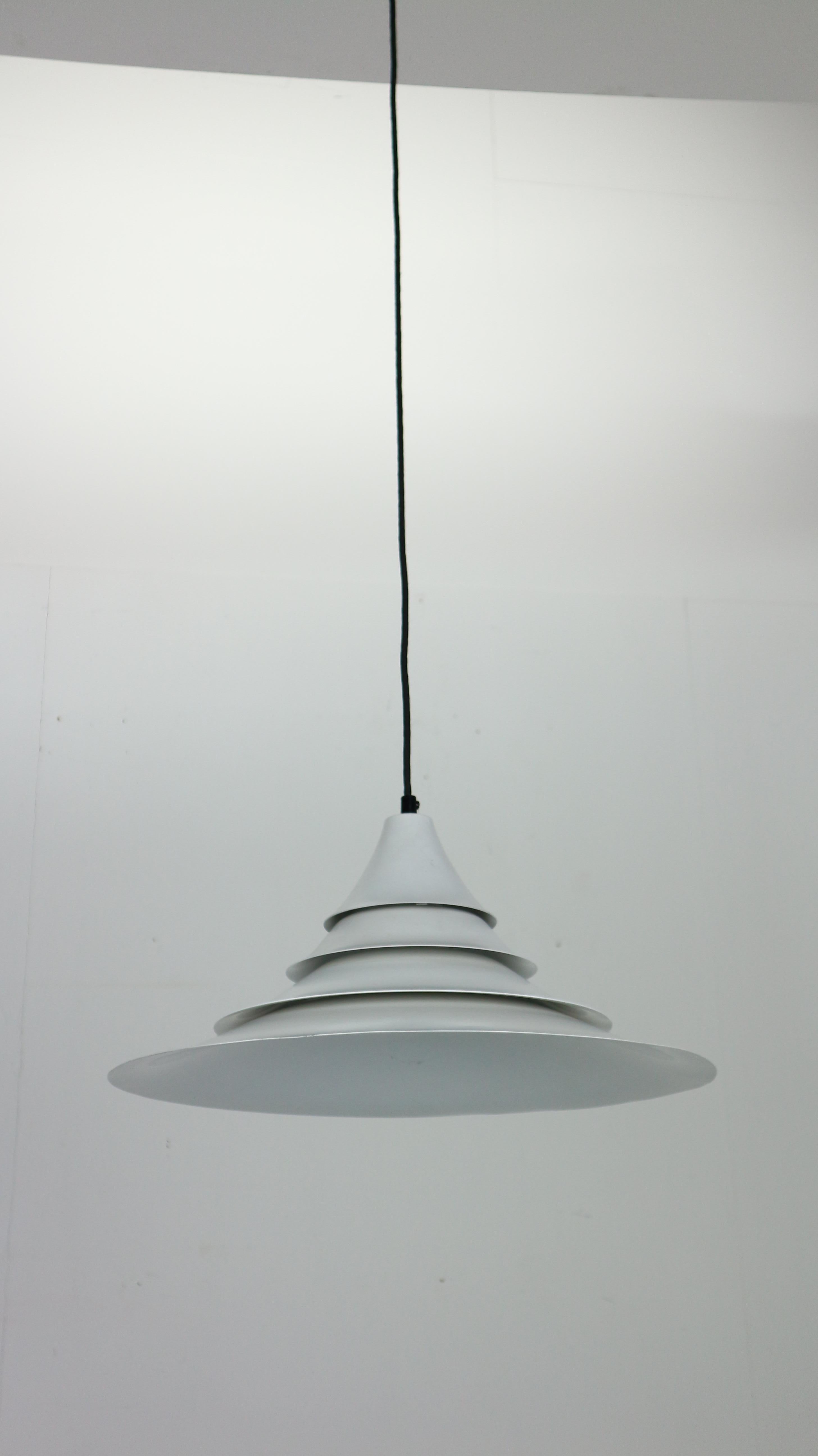 Weiße Hängelampe im modernen dänischen Design, hergestellt in den 1960er Jahren in Dänemark.
Die Lampe aus weißem Metall ist aus verschiedenen Scheiben zusammengesetzt und sorgt für eine warme und gemütliche Beleuchtung in Ihrem Designhaus.
Die