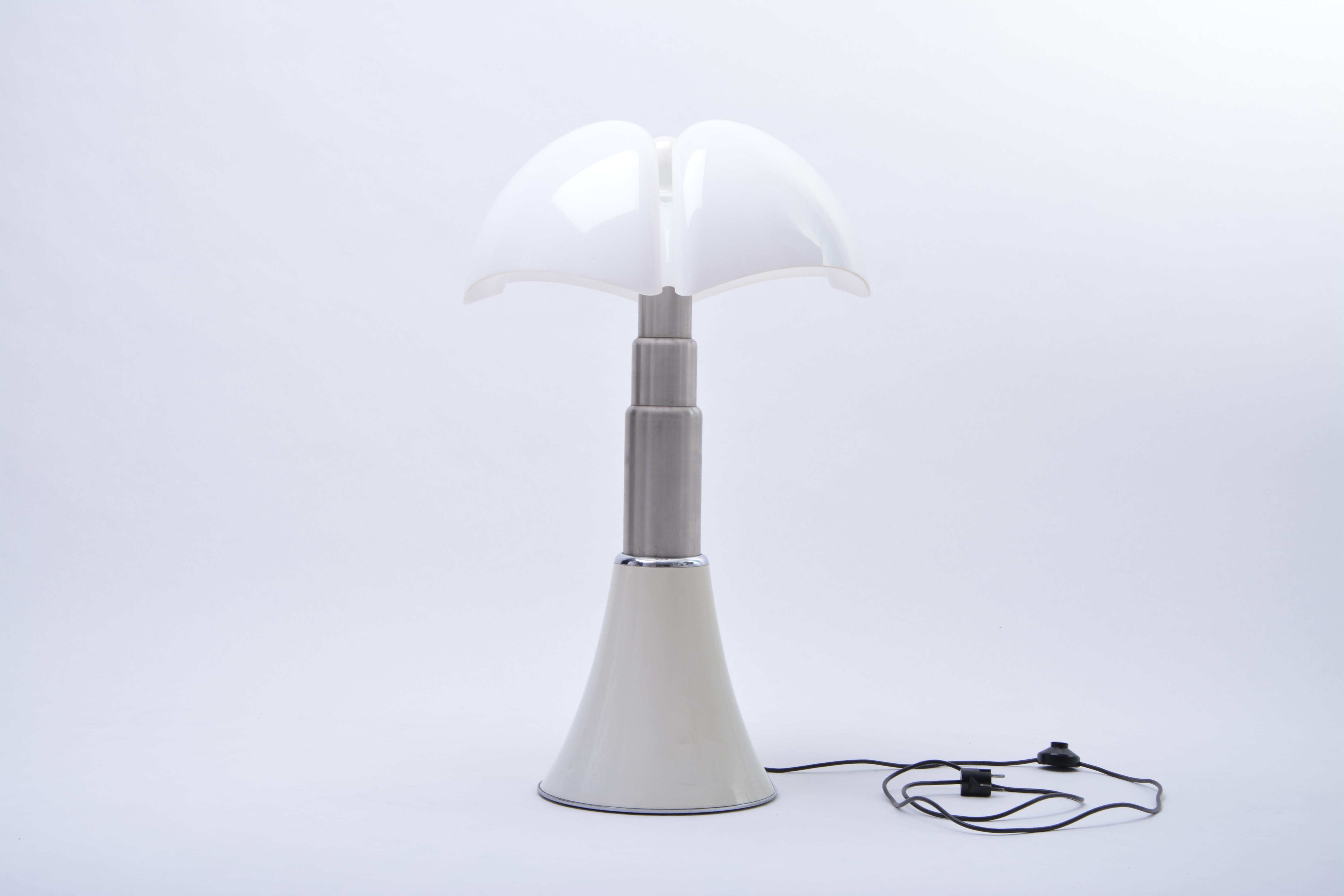 This iconic lamp designed by Gae Aulenti 1966 for Martinelli Luce is height adjustable by means of its stainless steel telescopic shaft. The shade is made of opal white plastic. Under the shade it has four light sockets. Height is adjustable from 72