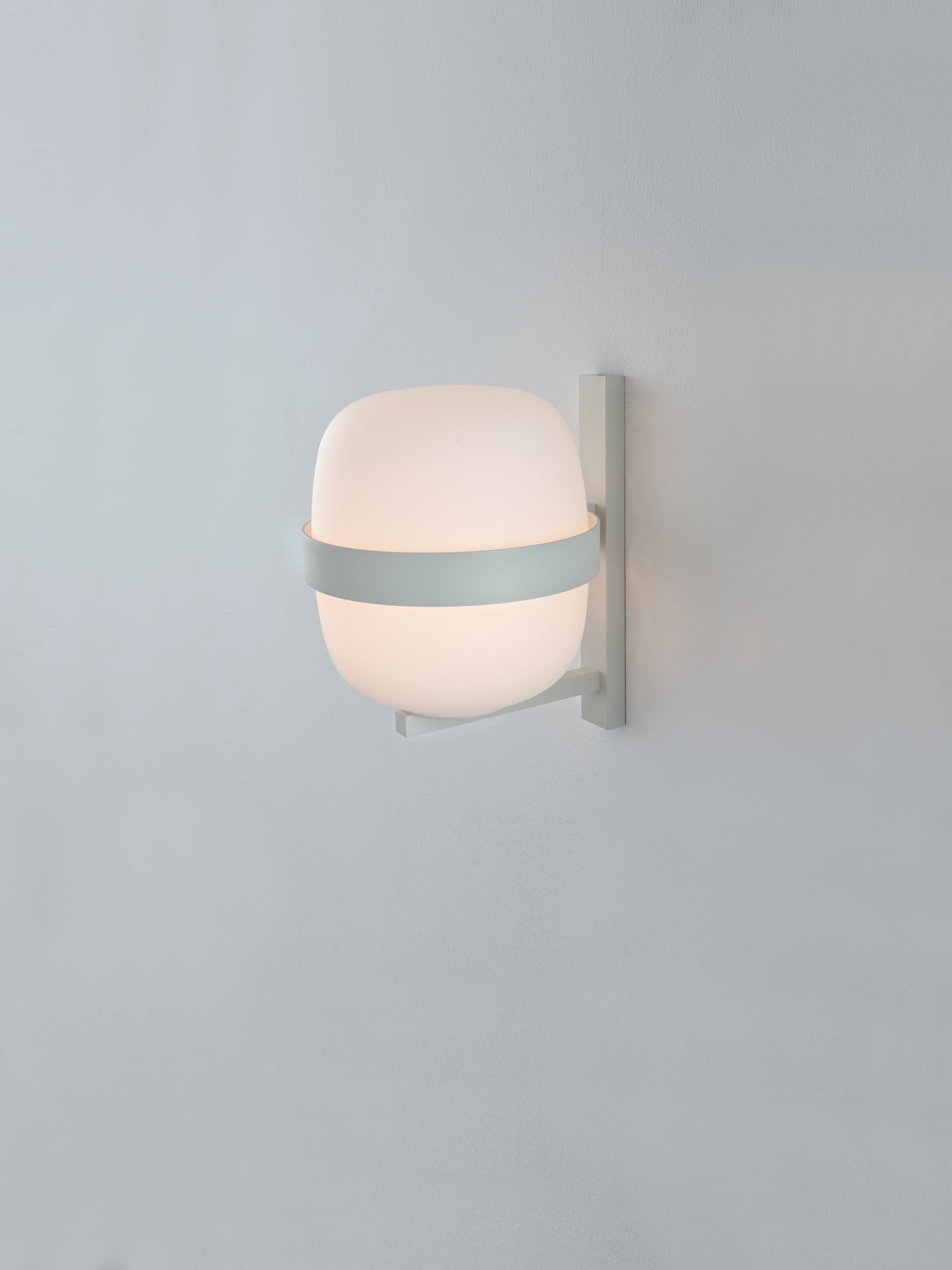 White wally wall lamp by Miguel Milá
Dimensions: D 18.4 x W 10 x H 24 cm
Materials: metal, glass.
Also available in black.

In the wally lamp, the iconic globe-shaped shade from the Cesta family is supported by a metallic ring in white or