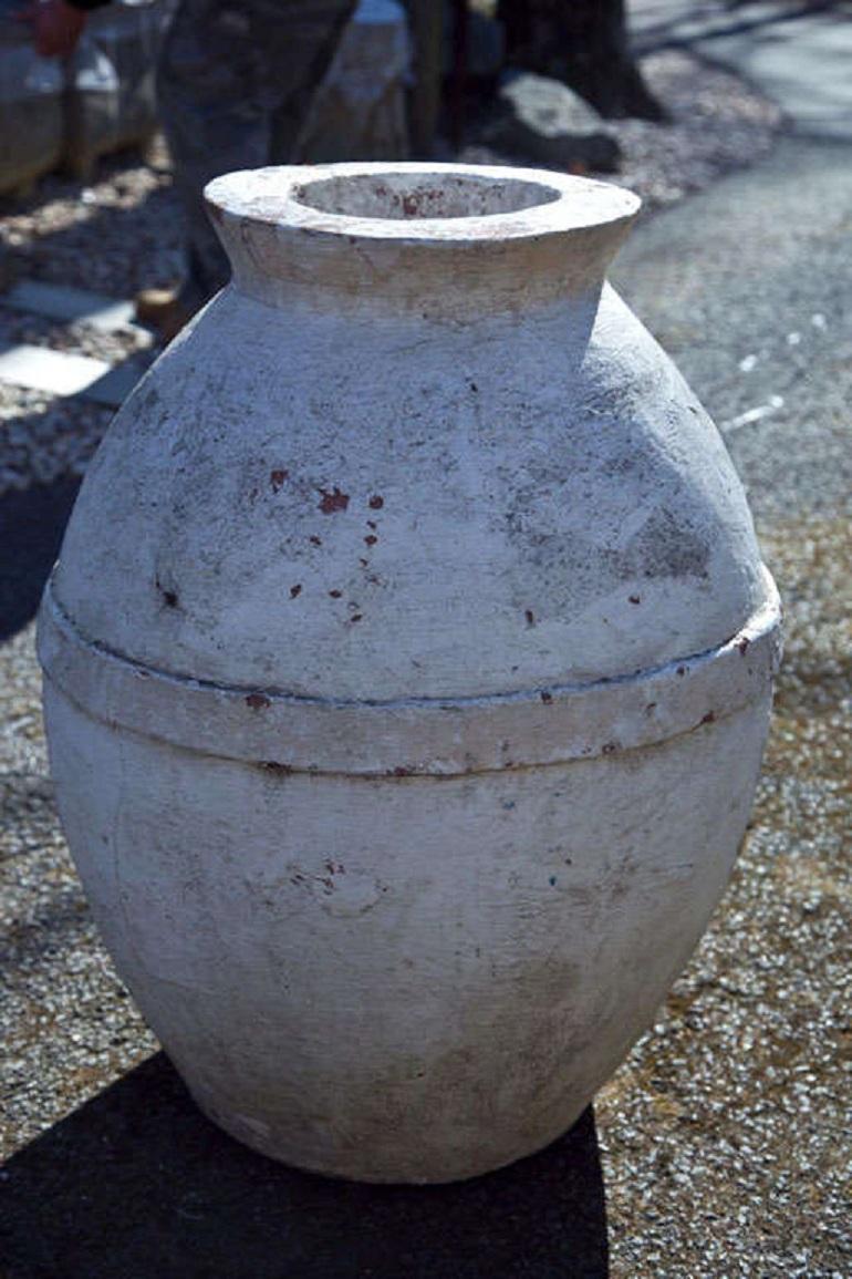 Large white washed cement storage jar.