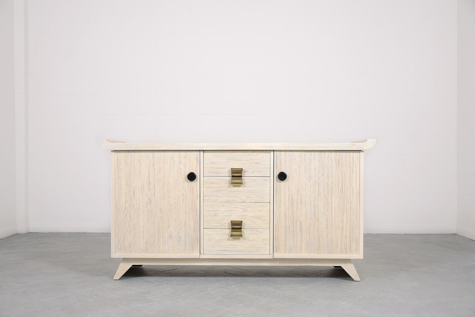 Introducing our striking 1960s white-washed server, masterfully hand-crafted from oak wood and meticulously restored to perfection by our seasoned craftsmen. The mid-century allure of this cabinet is undeniable with its chic white-washed hue, sealed