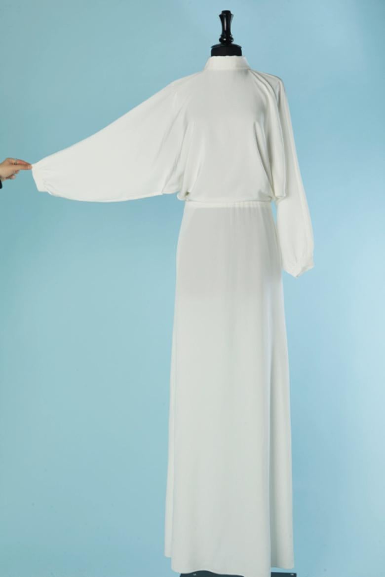 Robe de mariée (ou de soirée) blanche. Pas d'étiquette de composition du tissu, mais probablement de la rayonne. Fermeture à glissière et crochet invisible au milieu du dos. Fermeture par boutons et boutonnières aux poignets et un bouton et une