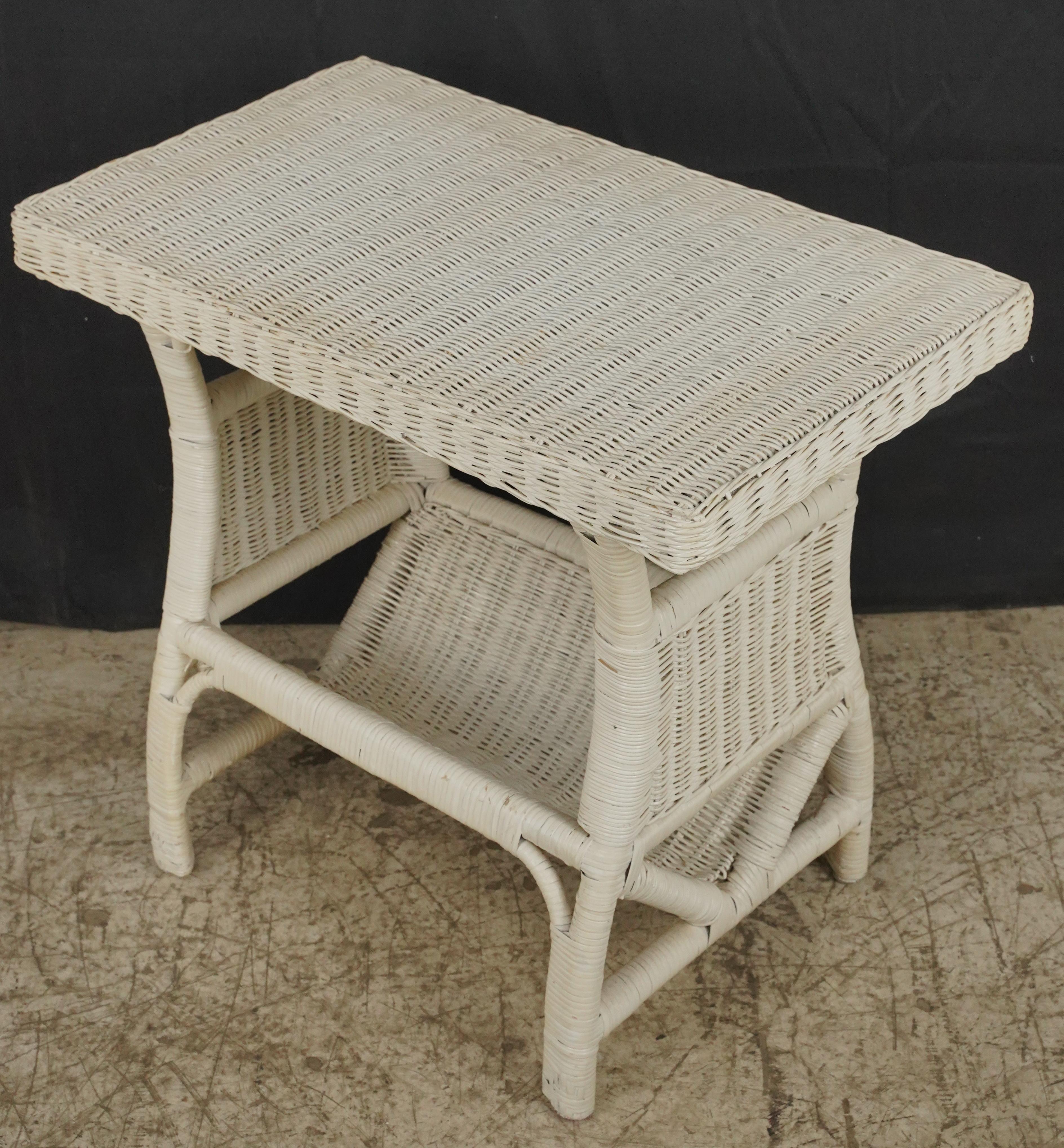 Rectangular end table made of white wicker. It features a lower area designed for magazines or newspapers. Good condition with surface wear from prior use. One available. Please note, this item is located in our Scranton, PA location.