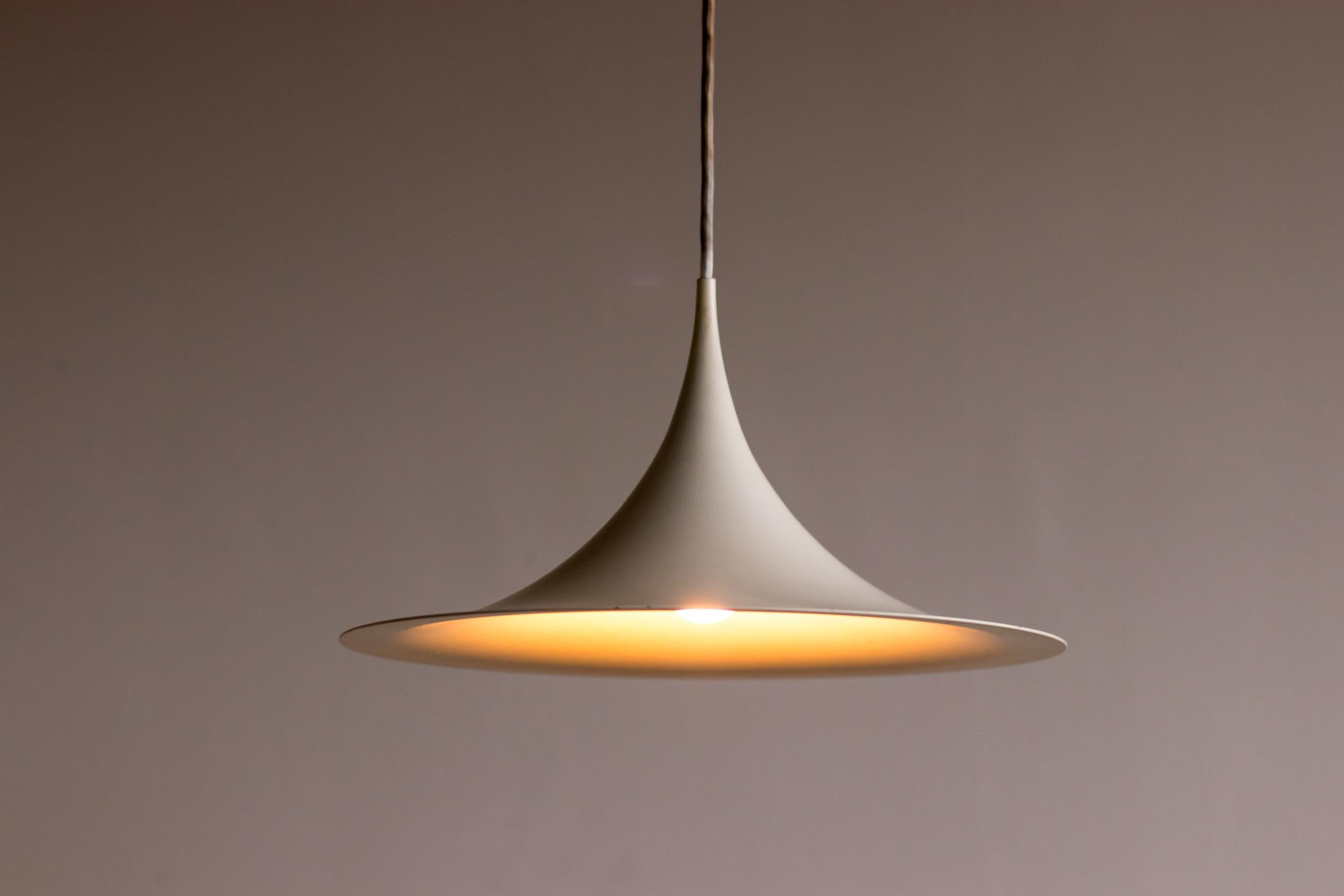 White enameled aluminium pendant lamp designed by Claus Bonderup and Thorsten Thorup for Fog and Mørup. Very early edition with bakelite hardware in exquisite vintage condition.
Marked with label.

Fog & Mørup was a Danish lighting design company