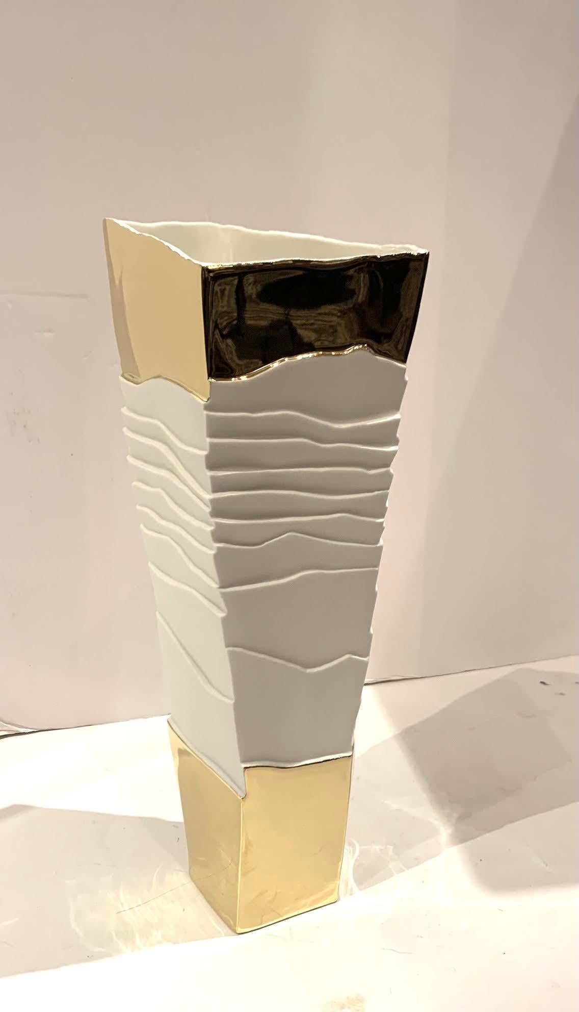 Vase en porcelaine blanche contemporain italien fait à la main avec un design cubiste.
Motif de nervures blanches ondulées et dessus et dessous en or 22K lisse.