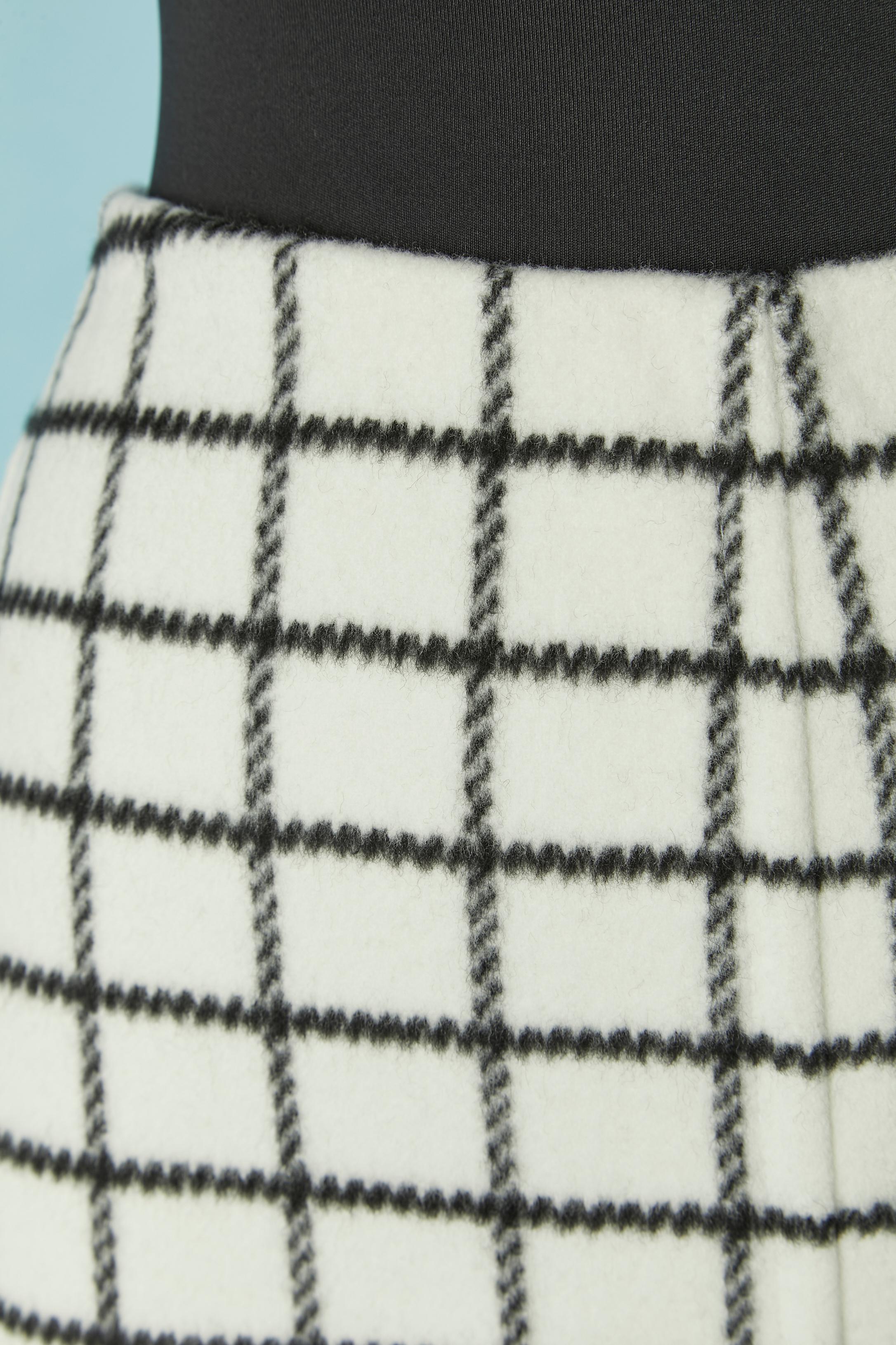 Jupe en laine blanche à carreaux noirs ; ruban en gros grain à l'intérieur de la taille. Pochette sur les deux côtés. Pas de doublure. Fermeture à glissière et crochet au milieu du dos. 
TAILLE L 
