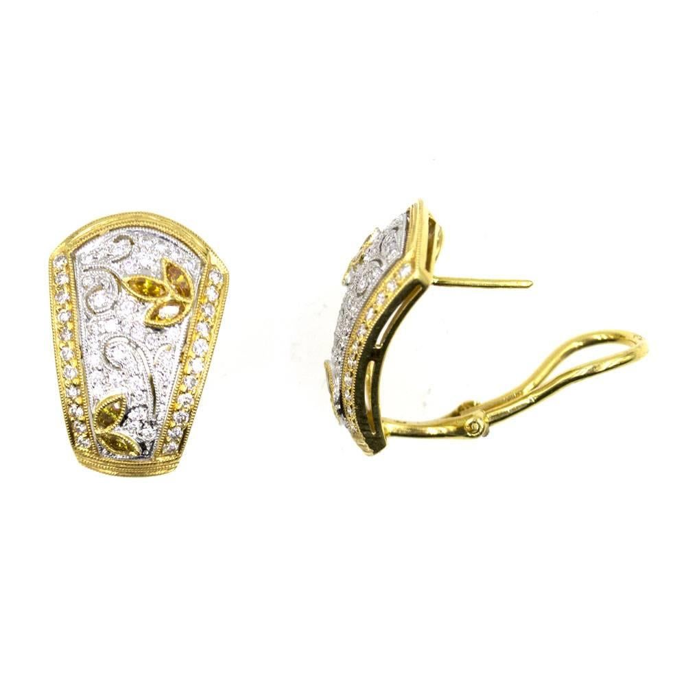 These stunning earrings feature white and yellow diamonds set in 18 karat two tone gold. The earrings can be worn with posts or as clips. The white and yellow diamonds equal 1.25 carat total weight and the earrings measure 15 x 22mm. 