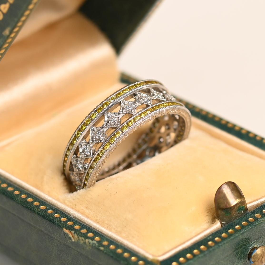 Cette alliance exquise présente un jeu étonnant de diamants blancs et jaunes, créant un design intemporel et élégant. Une rangée de diamants blancs brillants, de couleur approximative H et de pureté VS1, borde gracieusement le centre, rayonnant d'un