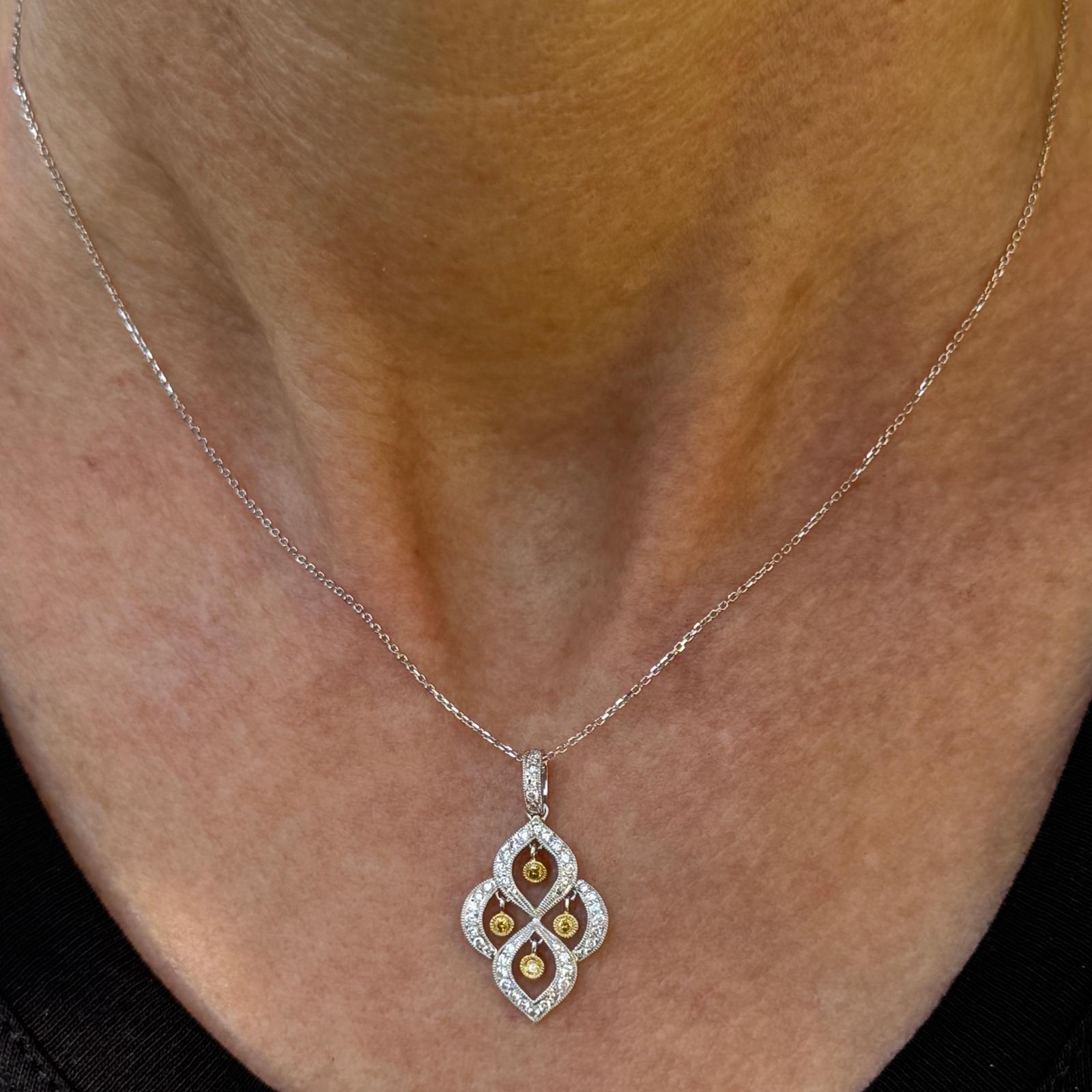 Questo squisito ciondolo in oro bianco 18 carati e diamanti gialli è una miscela armoniosa di eleganza e vivacità. Il pendente presenta 51 diamanti bianchi rotondi con taglio a brillante, di colore H+I e purezza SI, che creano uno sfondo