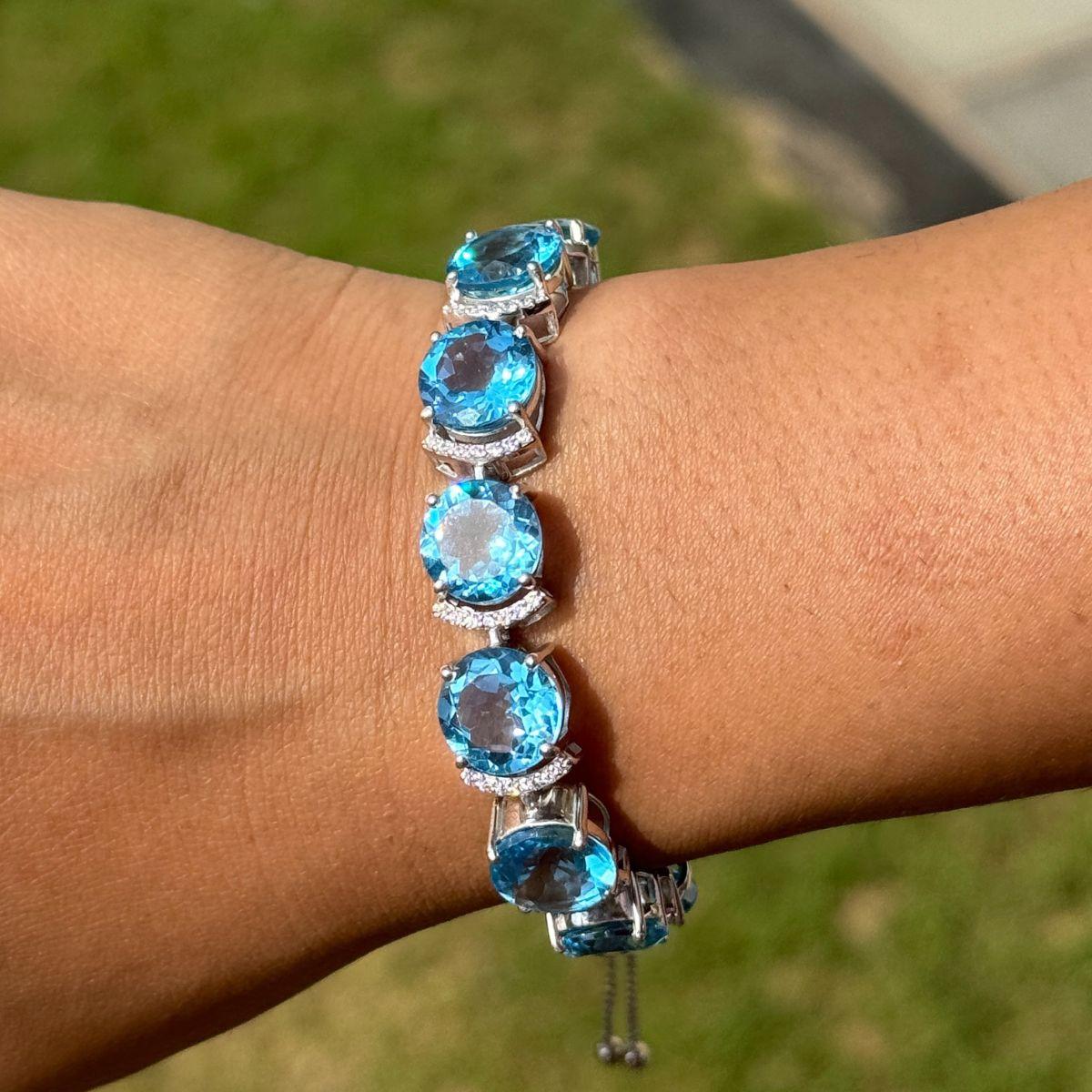 Ce bracelet bolo réglable en zircon blanc et topaze bleue est un bracelet bolo exquis de style tennis, fabriqué à la main en argent 925. Whiting, une série de pierres précieuses topazes bleues de taille ovale, chaque pierre est délicatement encadrée