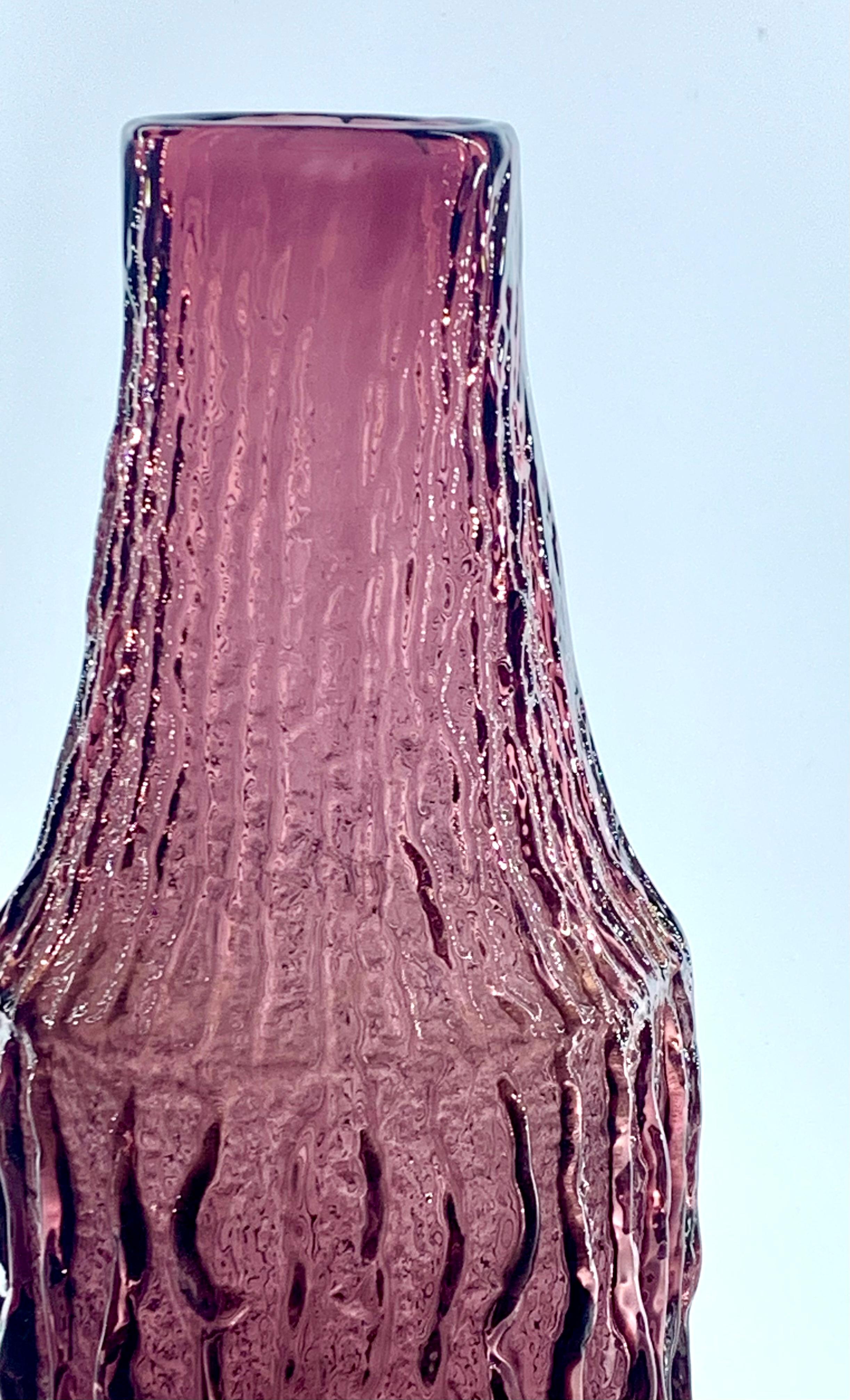 A Geoffrey Baxter designed for Whitefriars aubergine bark bottle vase, pattern number 9730.
Produced in 1969, it is in excellent condition.