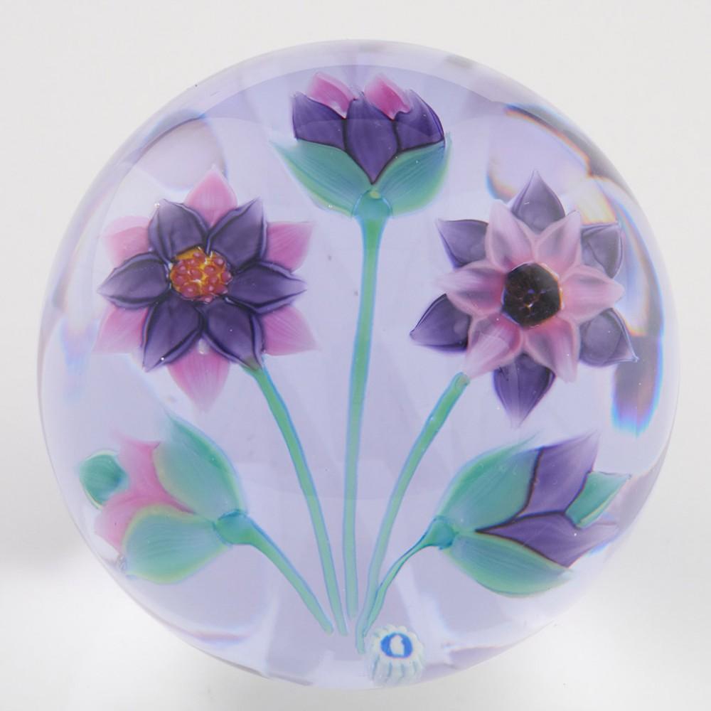 Heading : A Whitefriars Caithnesss Diamond Reflections Paperweight 1999
Date : 1999
Origin : Scotland
Features :Three lampwork purple and pink flowers with two buds with a diamond cut background
Marks : Whitefriars Caithness 25/50 Diamond