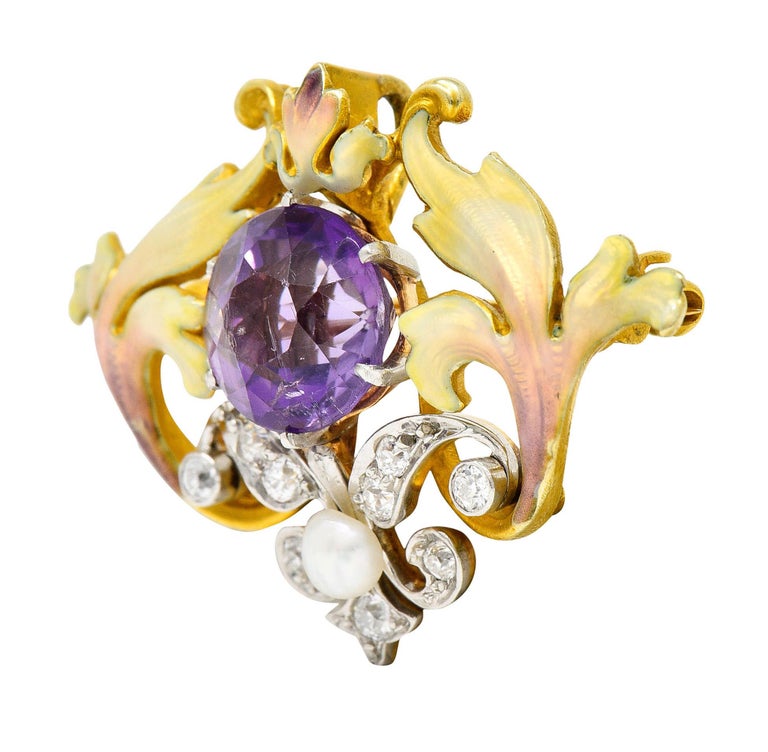 Pendant brooch is designed as scrolling whiplashed foliate glossed by green to pink ombrè enamel - minute loss

Centering a 10.0 mm round cut amethyst - medium light with pinkish purple color

Platinum is set with old European cut diamonds weighing