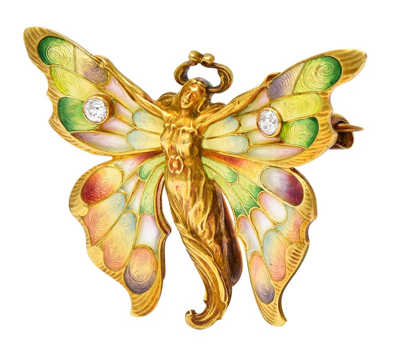 Brooch is designed as a winged fairy nymph - her figure is highly rendered in gold. With spread wings of glossed translucent and iridescent plique-a-jour and guilloche style enamel. Exhibiting no loss of ombré green, yellow, purple, pink, and blue