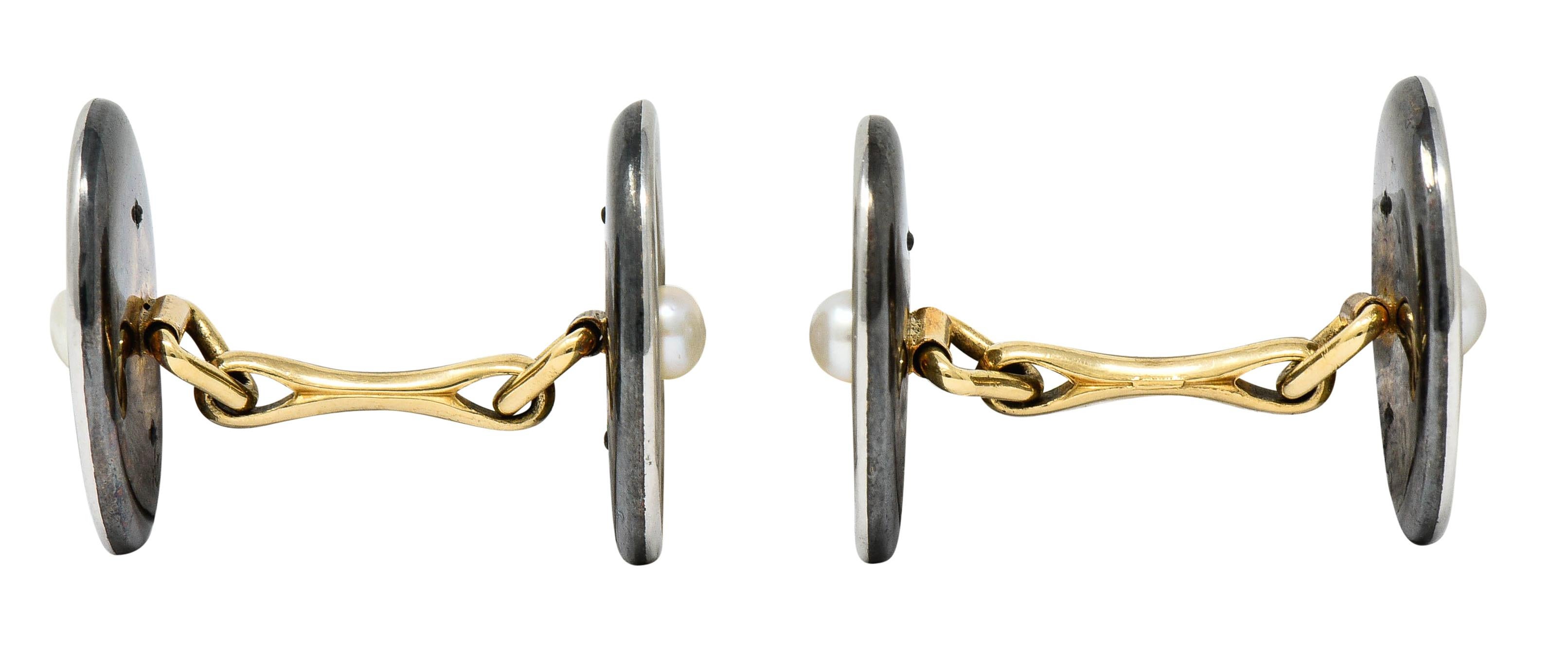 Link style cufflinks that terminate on both sides as oval forms with strongly oxidized backs

Centering 3.0 mm round button pearls with cream body color and excellent luster

Surrounded by highly rendered platinum laurel foliate; symbolic of