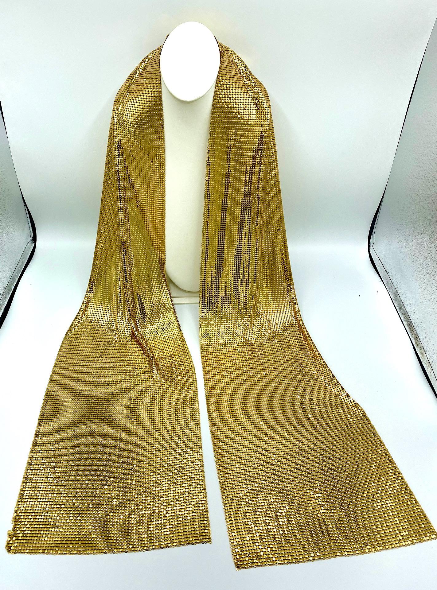Attributed to the Whiting & Davis Company famous for their mesh bags, clothes and accessories is this eye catching gold mesh scarf from the 1970s to 1980s.  The scarf drapes beautifully around the neck to hang loosely or may be wrapped over a