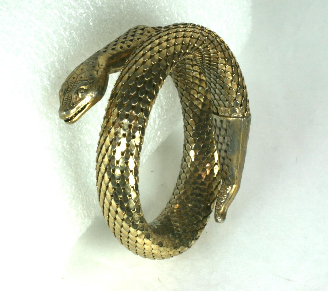 Whiting and Davis Coiled Snake Bracelet of pale gold metal with highly detailed finishes. Each scale is articulated in the metal mesh which ends in finely detailed head and tail end caps. Coiled to wrap around wrist or upper arm. 1960's USA. 
Width