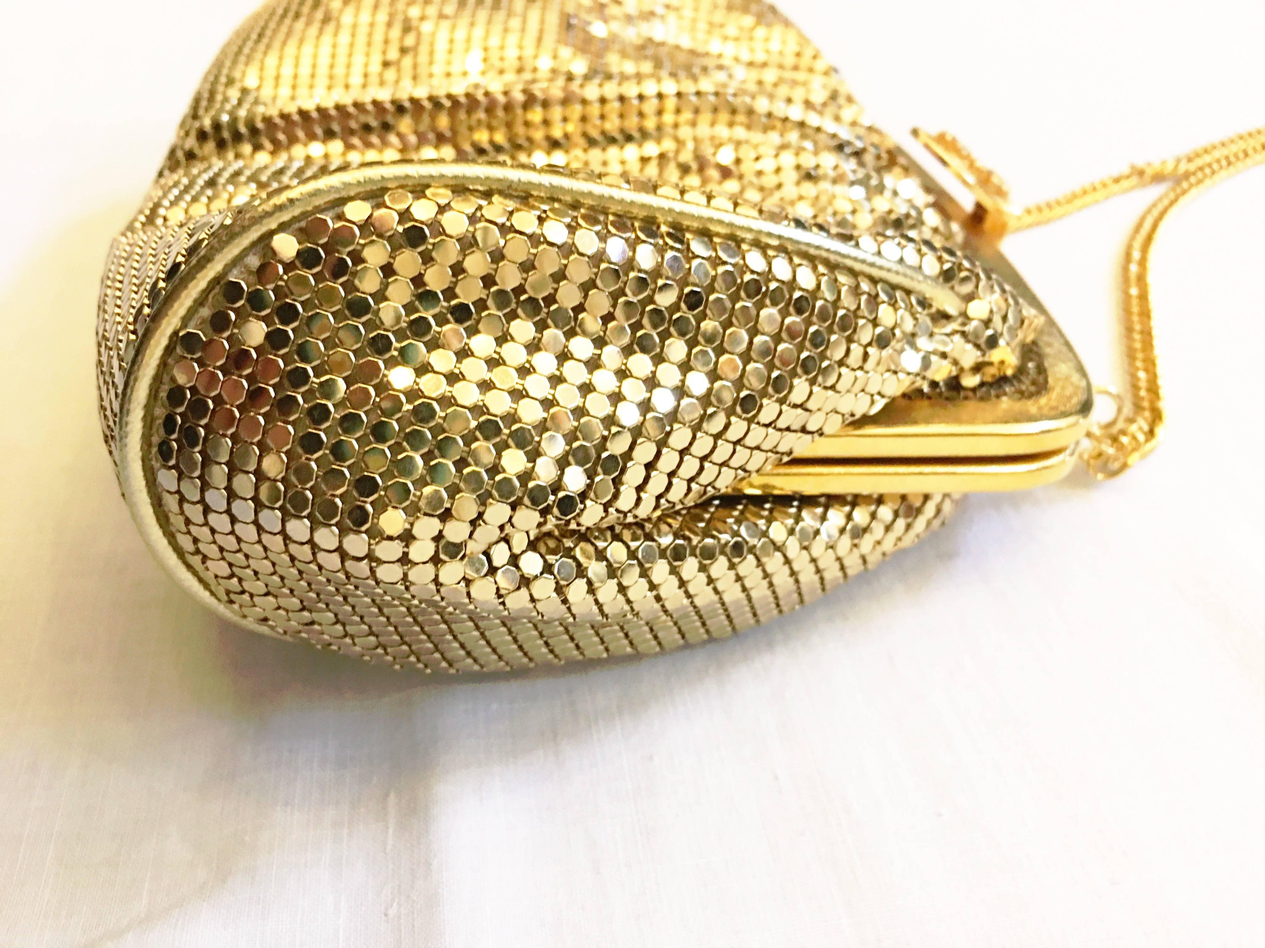 Gold evening bag in mesh. Fully lined. One inner zip pocket. Rhinestone embellished clasp. Includes original tag. Gold tone chain shoulder strap. Gold tone metal at top where the bag clasps and gold piping at trim. Perfect size to fit anything you