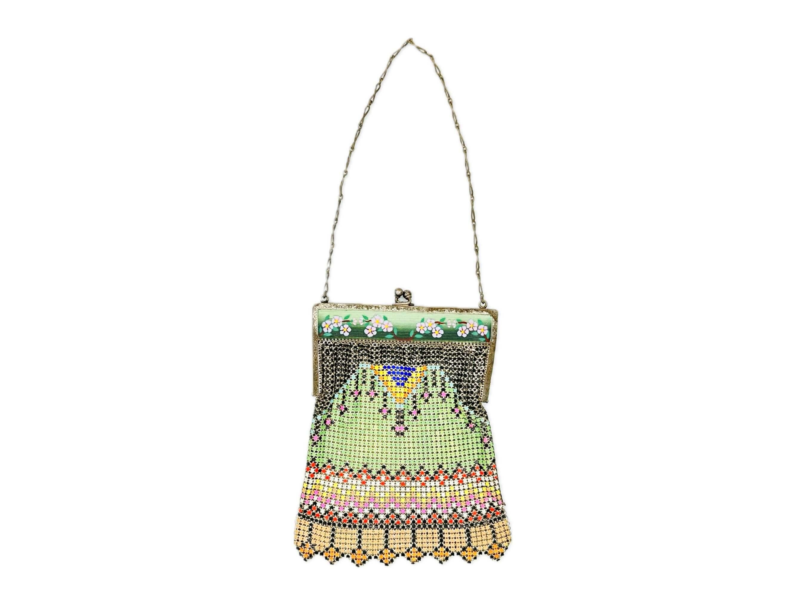 This wonderful Whiting & Davis metal mesh bag, circa 1920s, is a stunning piece of fashion history. The purse is comprised of colorful enameled armor mesh with a unique enameled frame. The front side of the frame is accented with delicate pink