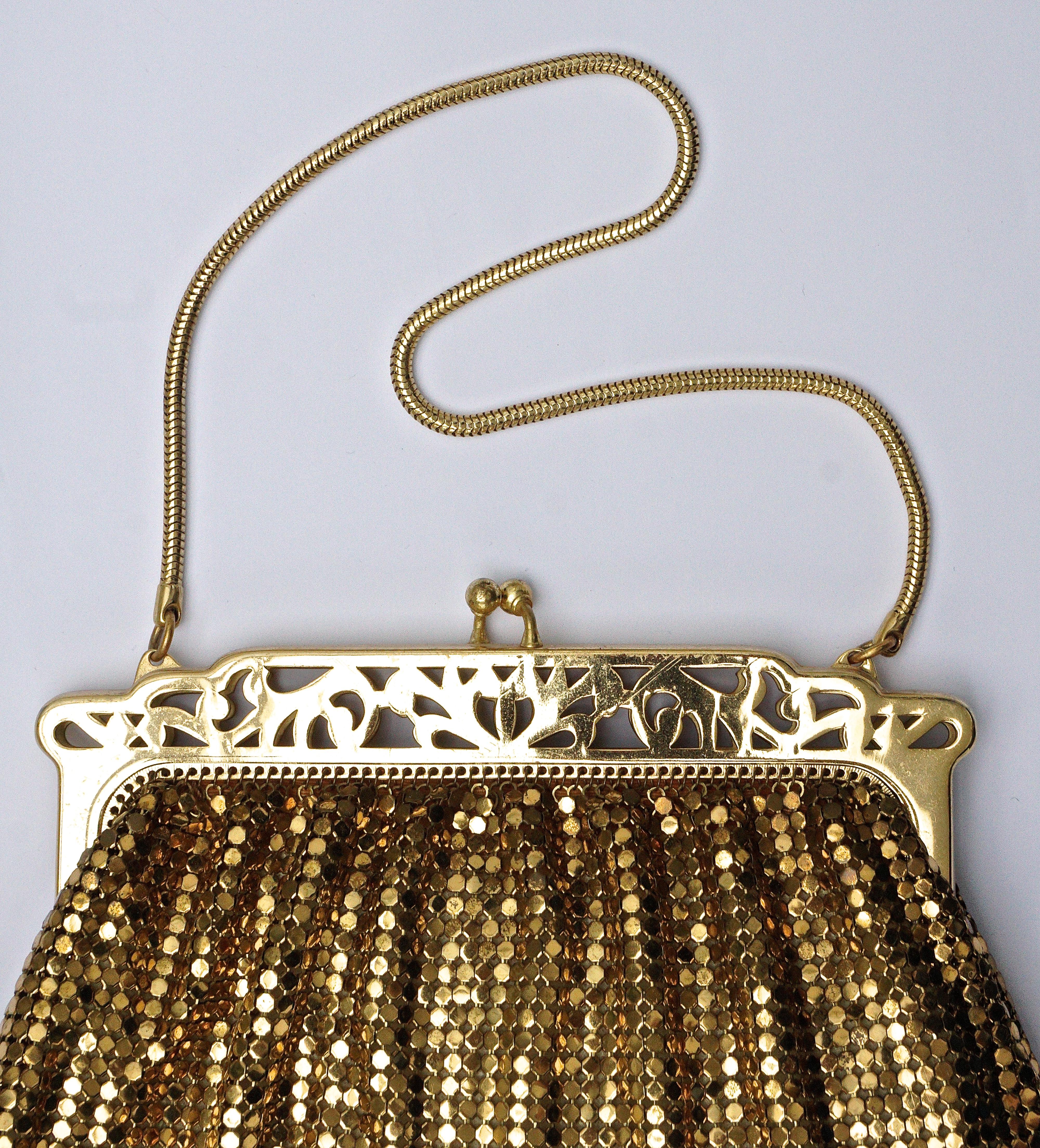 Beautiful vintage gold mesh bag by Whiting & Davis featuring a lovely cut-out frame, and snake chain handle.
Length 14cm / 5 1/2 inches, and the frame is width 13.3cm / 5.23 inches, the chain handle has a drop of 14.8cm / 5.8 inches. The peach