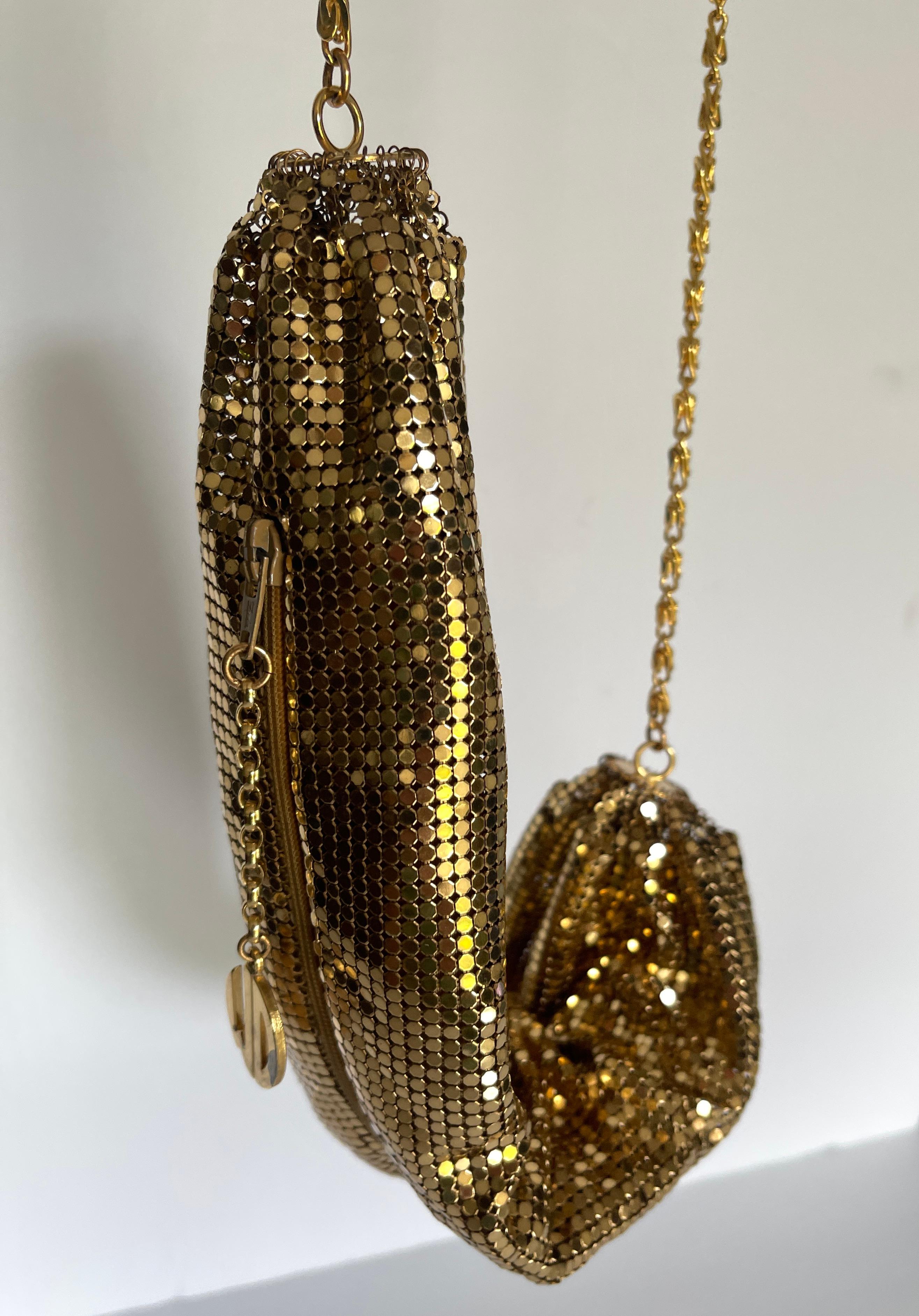 Gorgeous vintage Whiting & Davis gold metal mesh cross body evening bag with rayon satin lining and gold tone chain strap.. The zip closure along top edge of bag measures 8.5 inches. WD logo hanging charm has some discolouration, as pictured.

