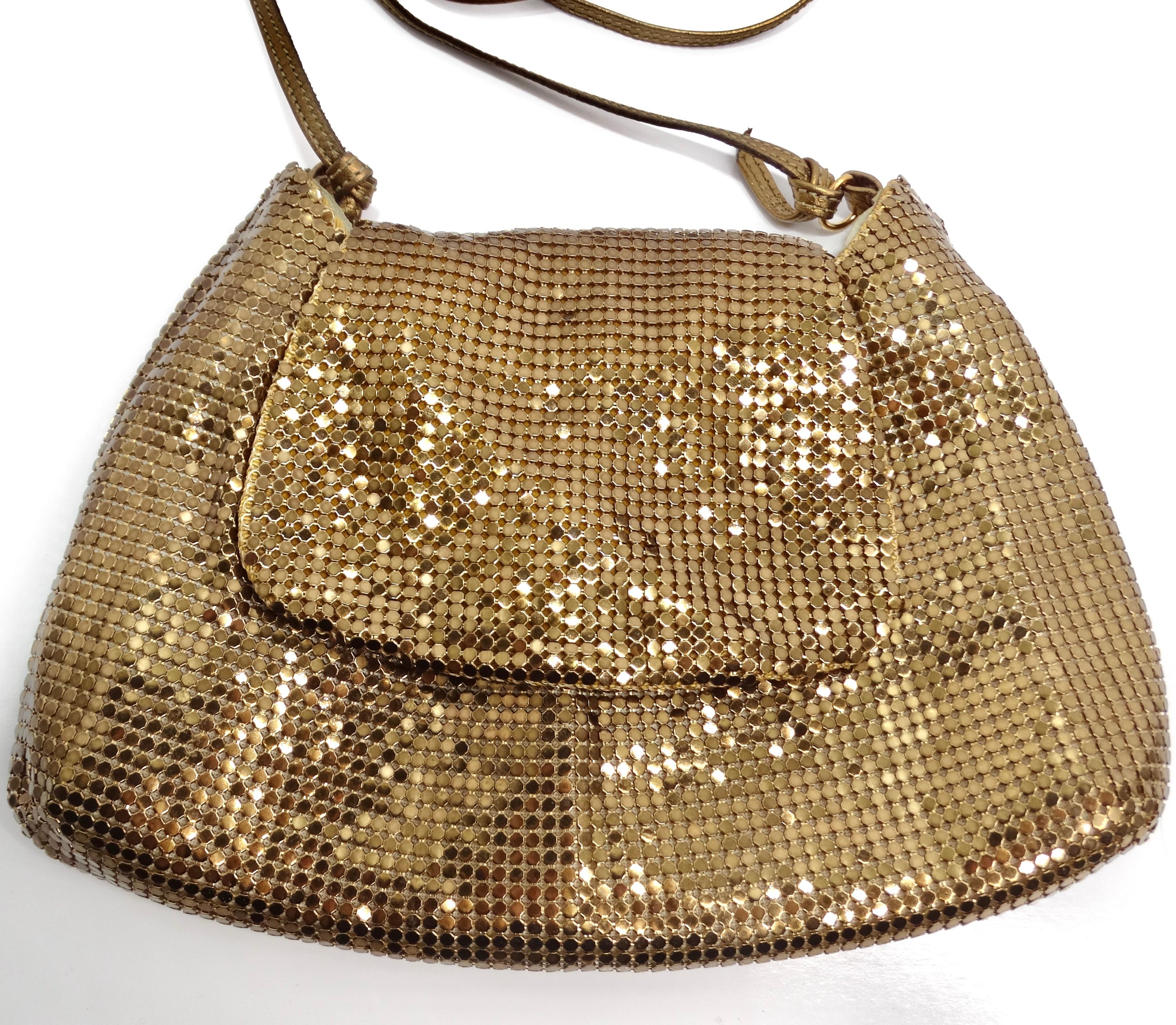 Rehaussez votre style avec le sac à bandoulière en chaîne de maille ton or de Whiting & Davis, un accessoire intemporel et glamour qui exsude un charme d'inspiration vintage. Fabriqué à partir d'une superbe cotte de mailles dorée, ce mini sac à