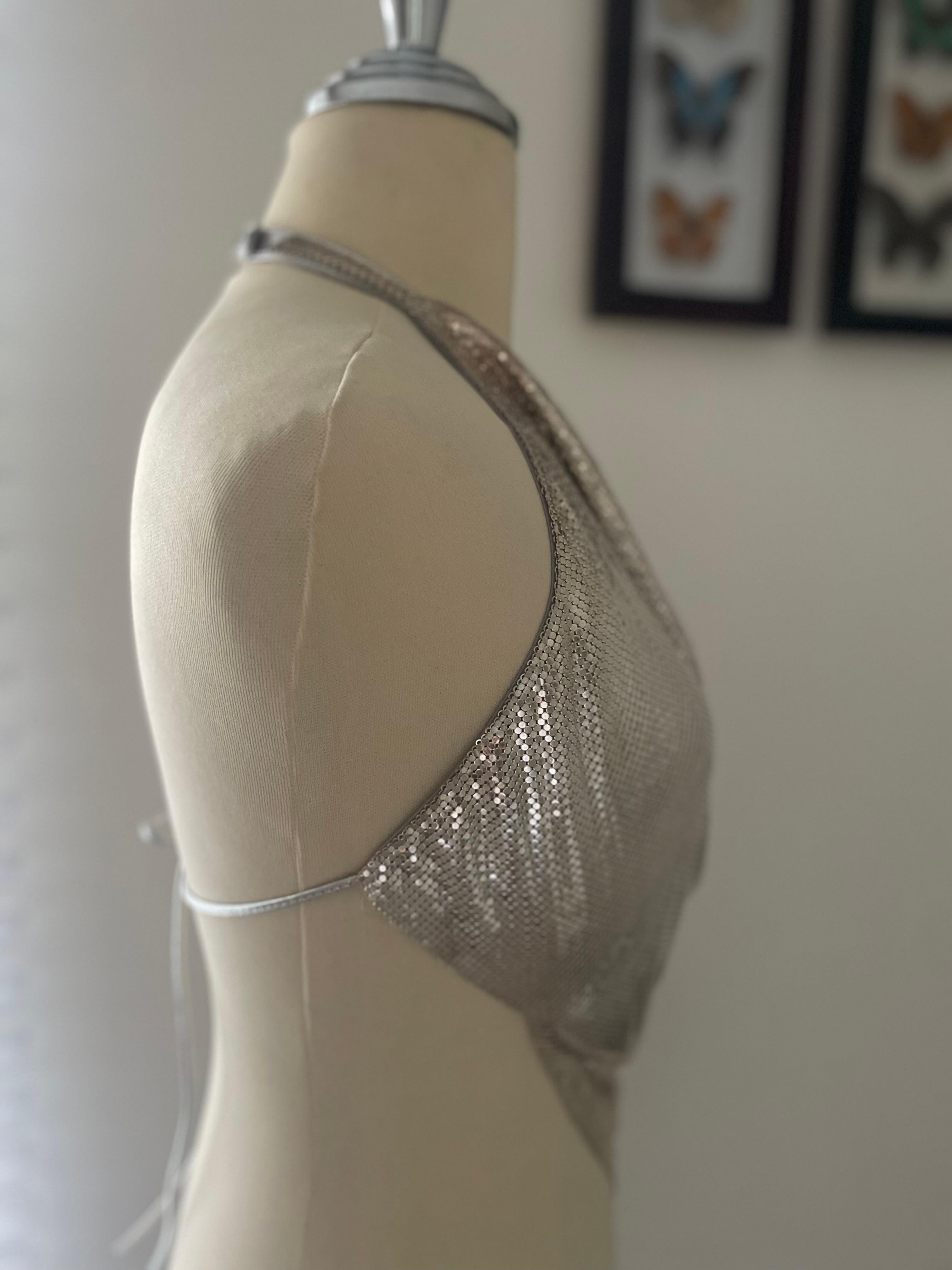 Do you want to shine? This very RARE and exceptional 1990s Vintage silver-tone chainmail Halter Top by Whiting & Davis made in USA, is a one of a kind piece and hard to find a similar. Handkerchief hem. Snap and tie closures at back. About 19
