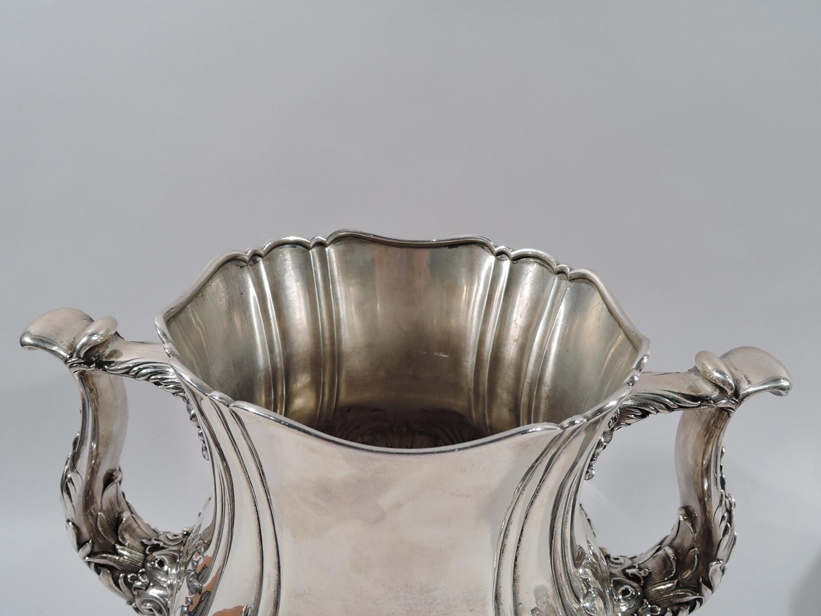 Turn of the century Classical sterling silver trophy. Made by Whiting in New York. Baluster body with scrolled rim and scroll-bracket side handles. Foot raised with scrolled rim. Body has vertical slash lines and dense and overlapping chased leaves.