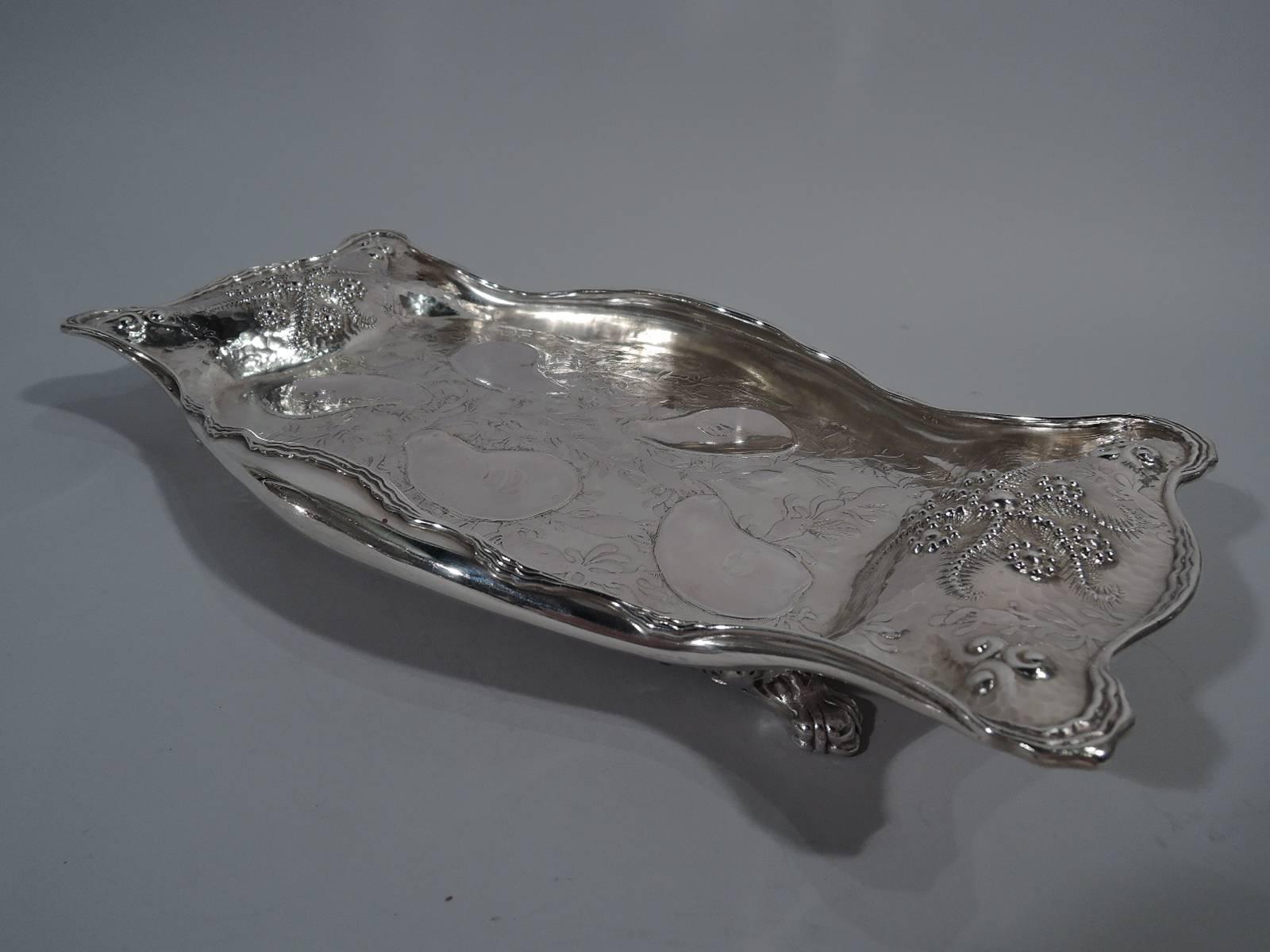 Aesthetic sterling silver oyster tray. Made by Whiting in New York, circa 1885. Shaped with well and hand-hammered scrolled end brackets. Turned-in rim with rippled reeding. Stylized ornament tending to abstraction with acid-etched algae and beaded