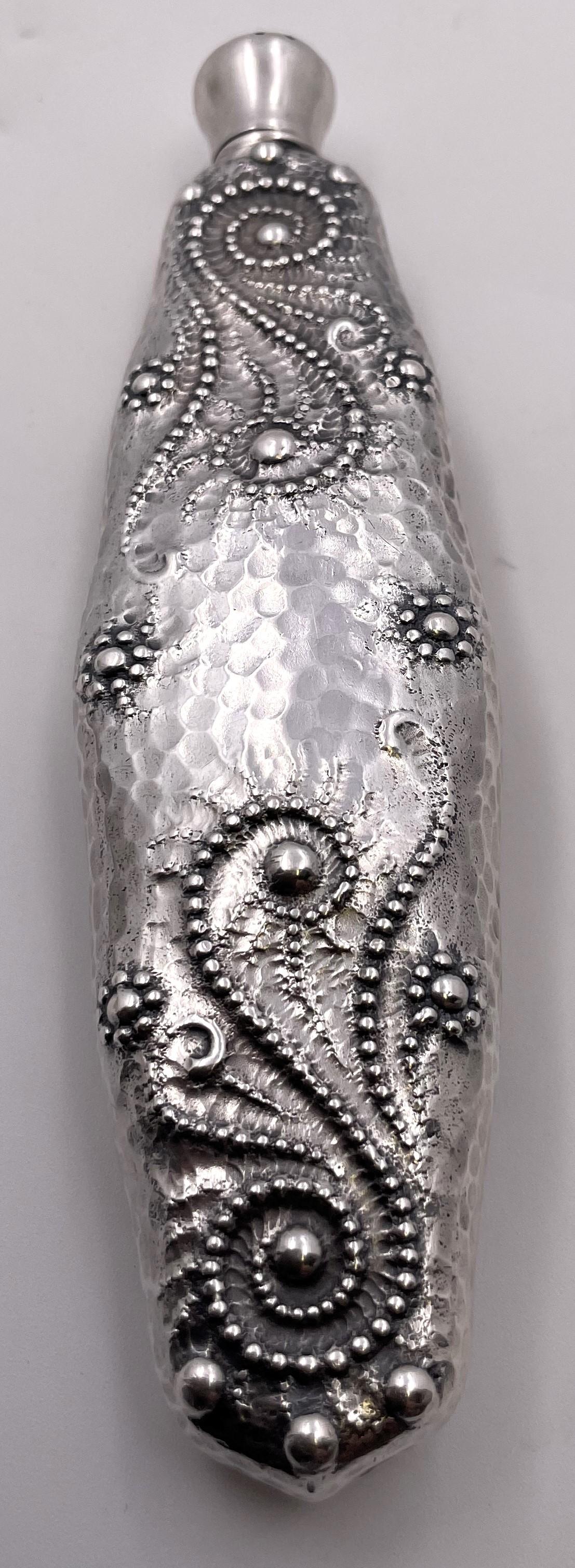 Designed by Charles Osborne for Whiting in the 1880s (pattern number 1255), this perfume bottle or scent vial with a nautical theme has an exquisite hand-hammered surface and has bead-liked motifs, all in Japonesque style. It measures 6'' in length