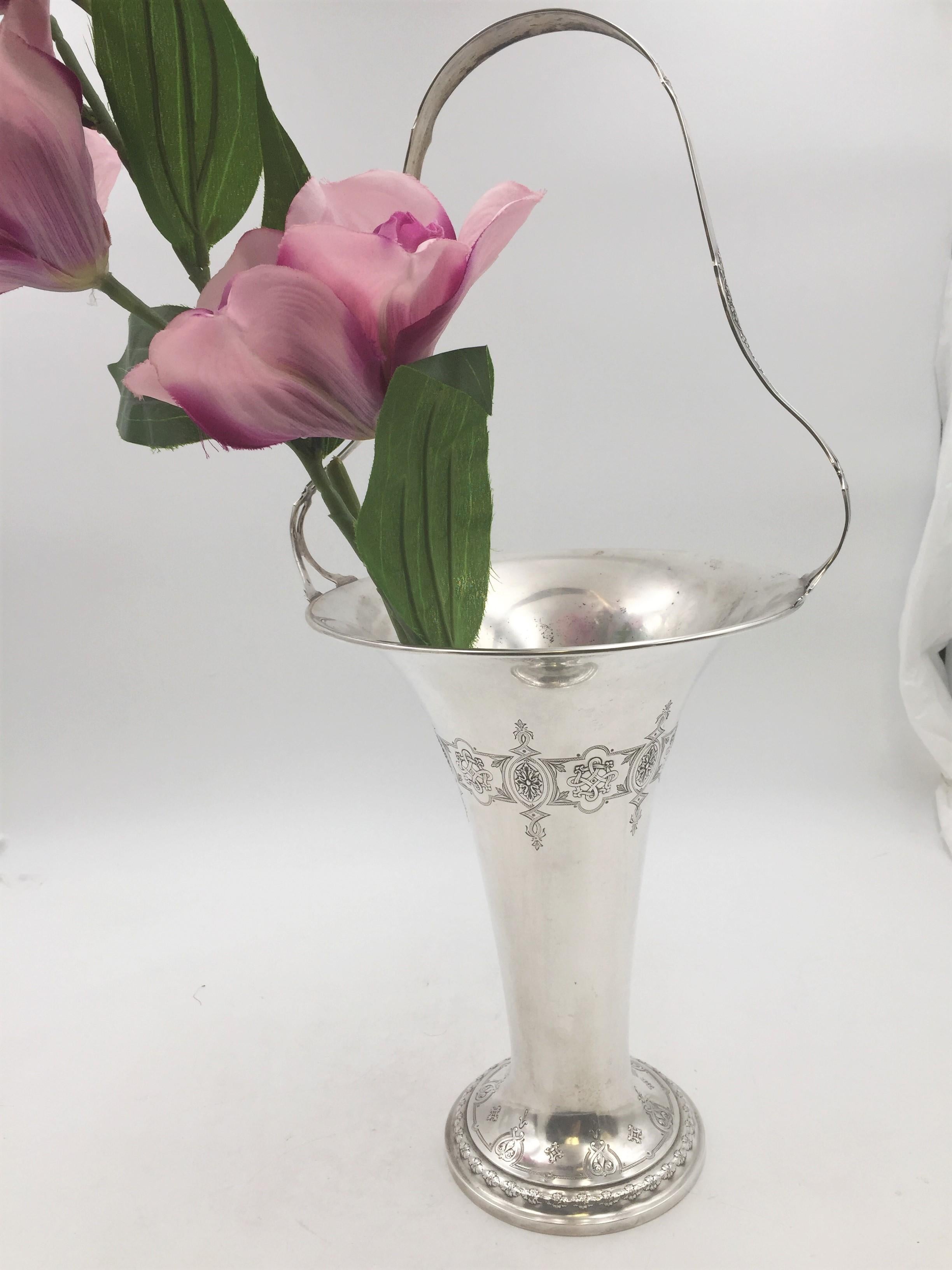 Late 19th or early 20th century Whiting sterling silver vase with handle or pedestal basket with ornate, stylized, natural and geometric patterns on the handle, around the body, and around the base. It measures 19 3/4'' in height (including the