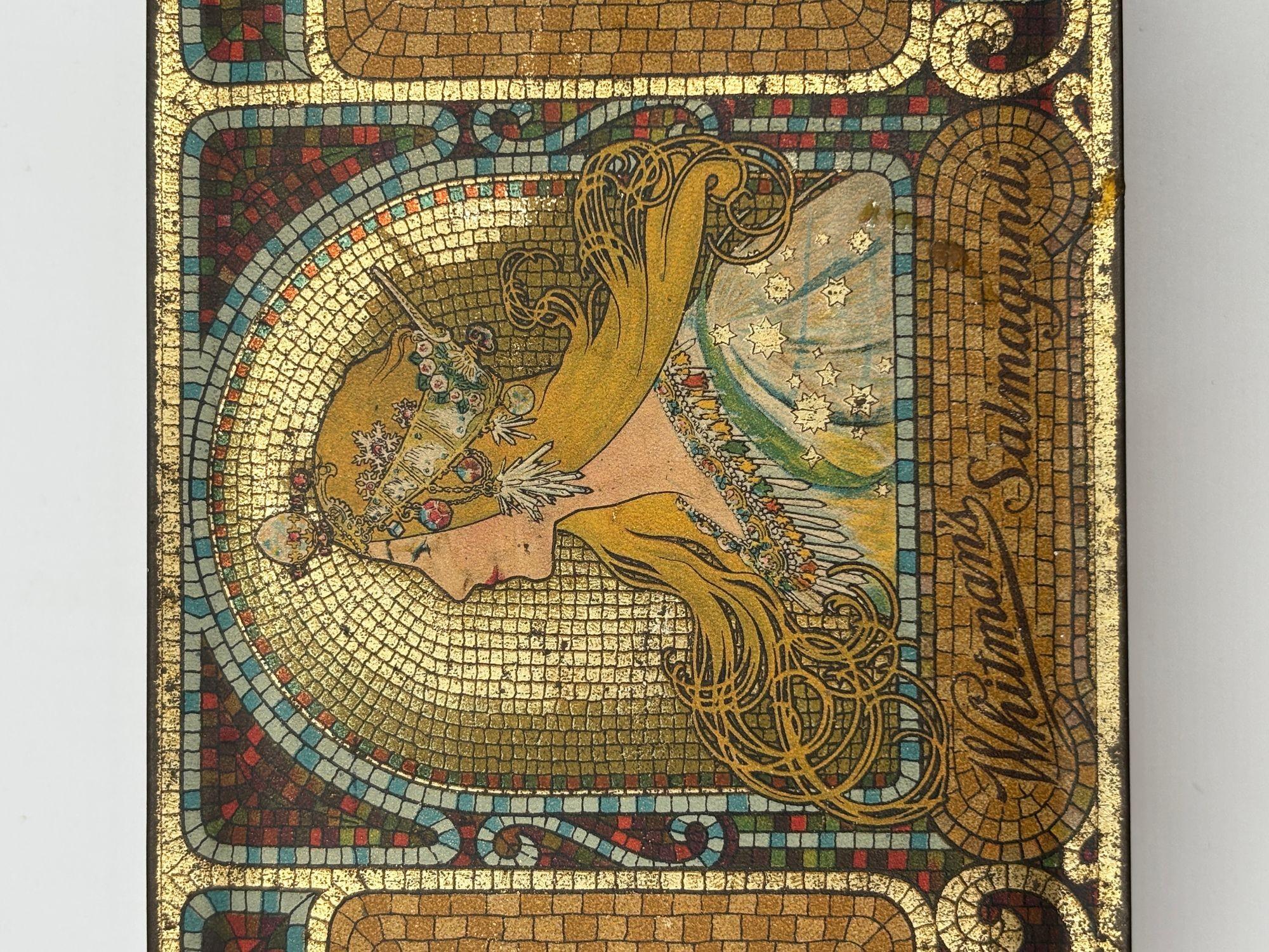 Boîte à chocolat Salmagundi en métal doré de 1920 de Whitman, avec un portrait d'Alphonse Mucha et des motifs Art nouveau sur le dessus et les côtés de la boîte.

Messurments 2-1/8