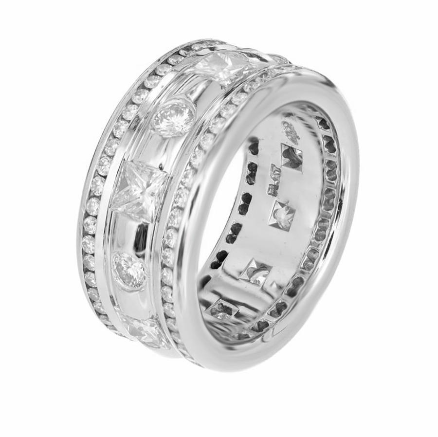 From designer Whitney Boin comes this spectacular diamond platinum, triple eternity wedding band ring. The center has alternating 6 brilliant and 6 princess cut diamonds with and approximate total weight of 1.88cts. The top and bottom outer rims are