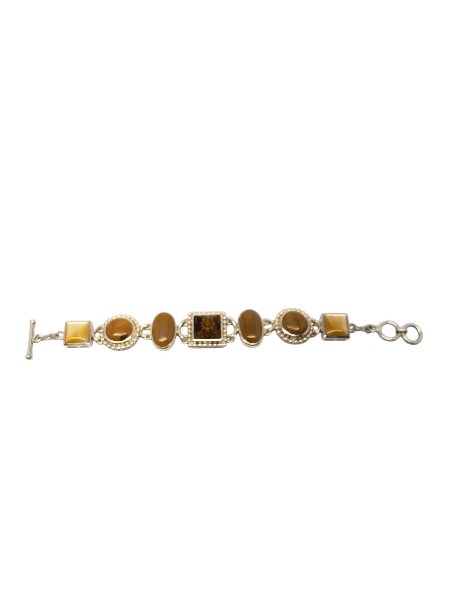 Whitney Kelly Sterling Silver Carved Multi Stone Bracelet -

This unique bracelet by Whitney Kelly features a carved tiger eye center with yellow agate, jasper, and mother of pearl set in sterling silver.

Size: 8 in.

Stamped: WK 925 CHINA

Weigh: