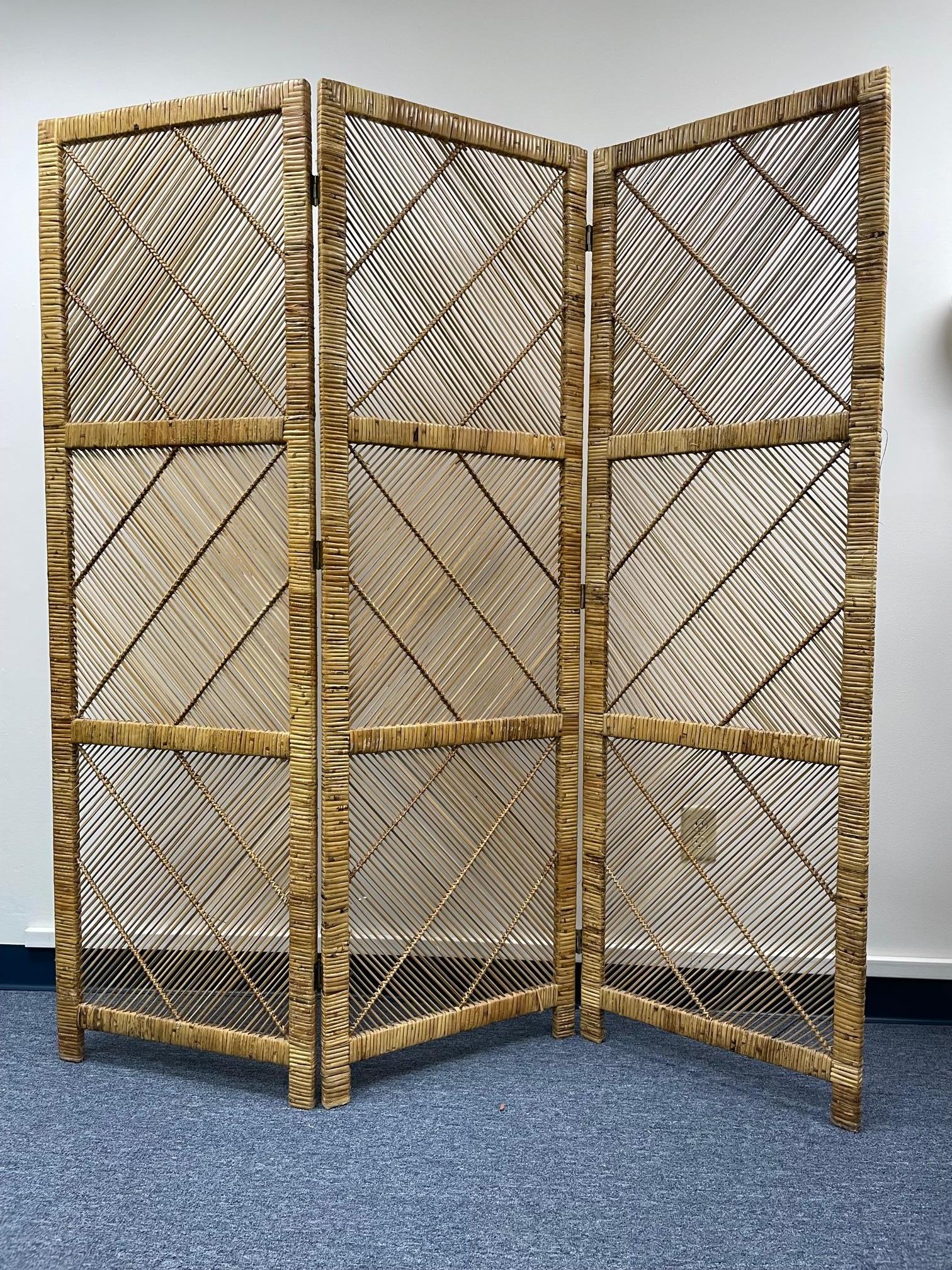 Cette séparation de pièce en osier vintage comporte trois panneaux avec un motif géométrique tissé. Bon état avec des imperfections mineures correspondant à l'âge.

 